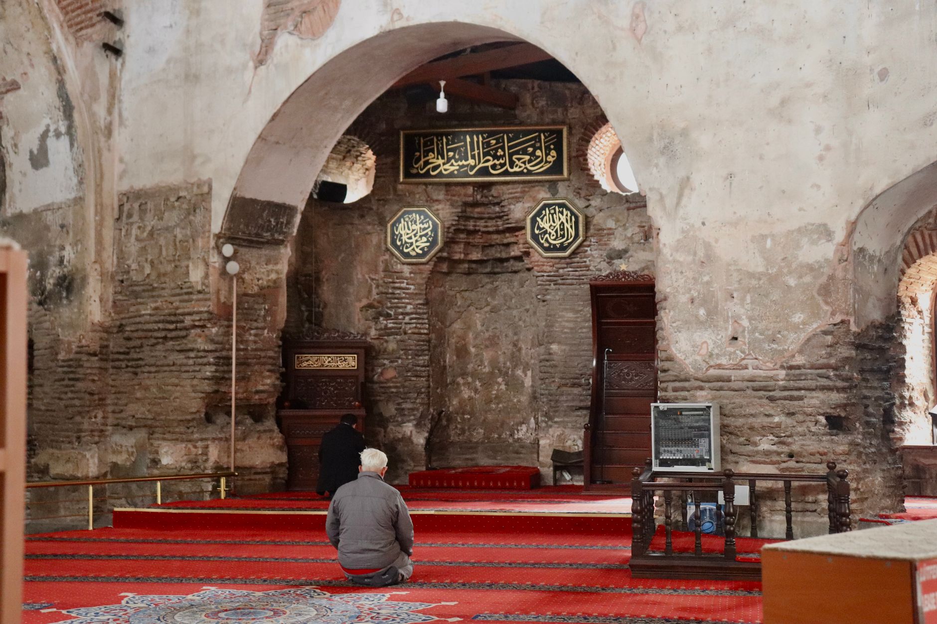 مصلون يؤدون الصلاة داخل مسجد، يظهر الداخل المفروش بالسجاد والجو الهادئ.
