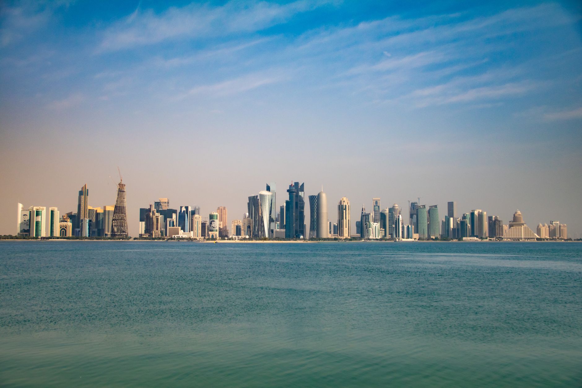 A panoramic view of the Doha skyline with modern skyscrapers and clear skies.