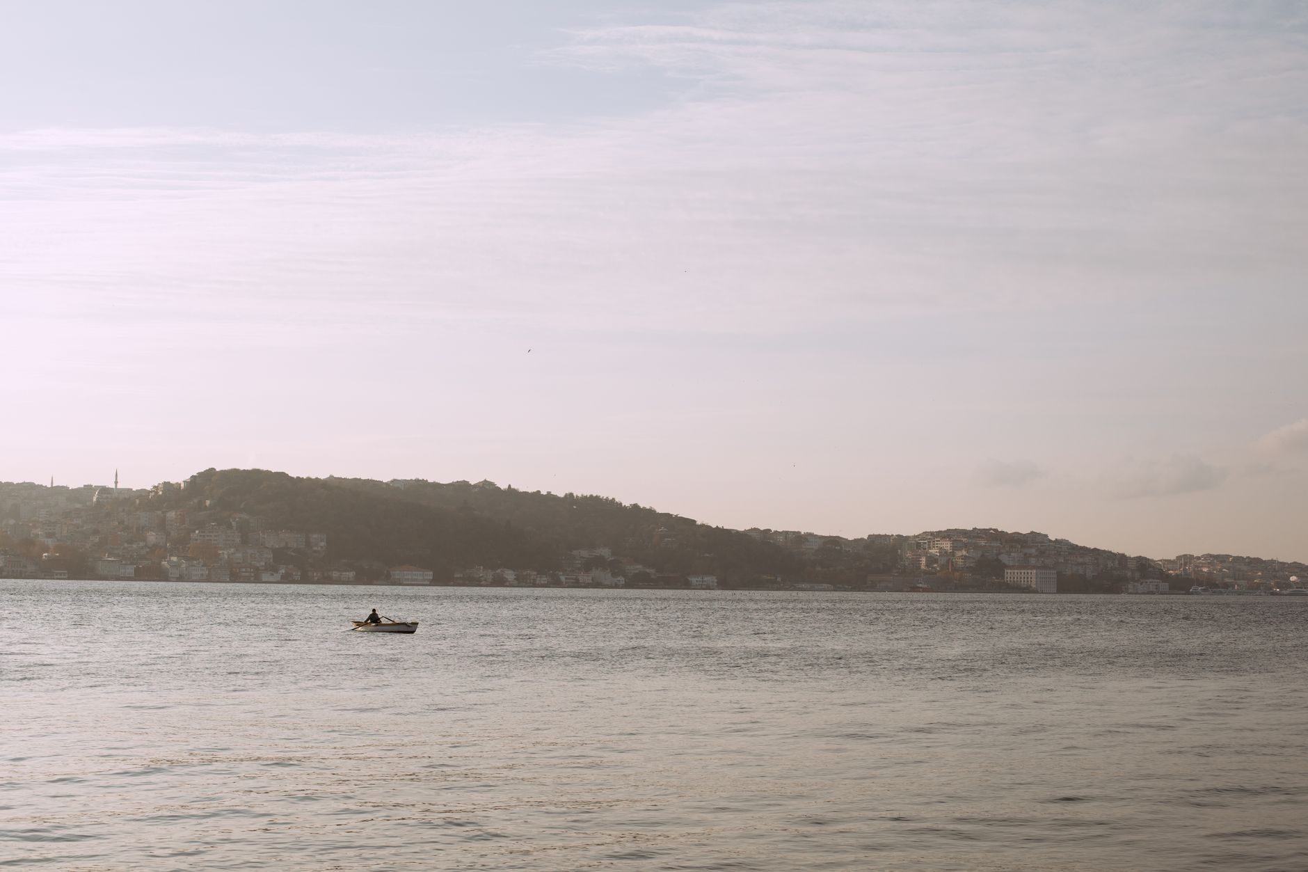 A tranquil scene of the Bosphorus with a lone kayaker, showcasing Istanbul's beauty.