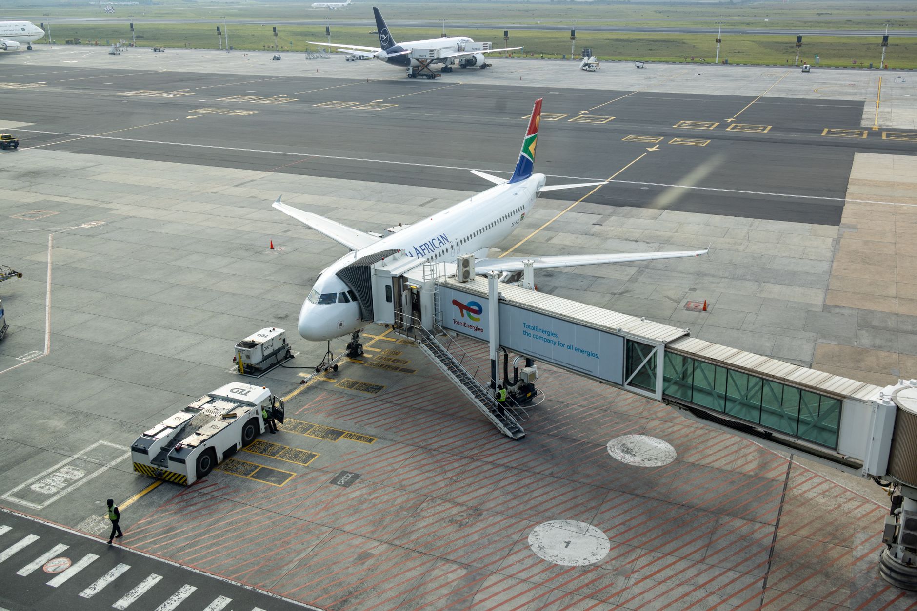 An airplane at the airport with a jet bridge, showcasing efficient transfers for medical tourism.