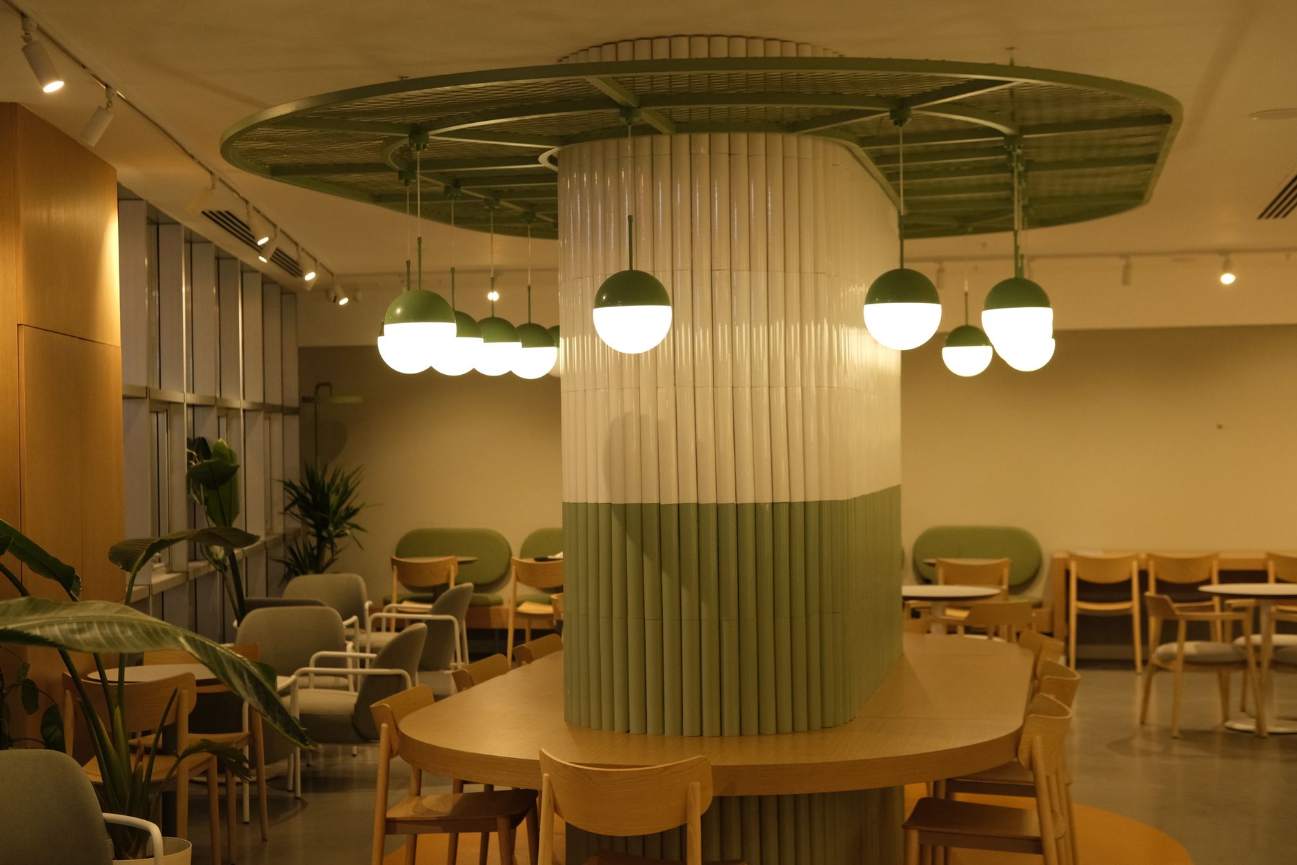 Contemporary hospital area featuring green decor, pendant lights, and seating arrangements.