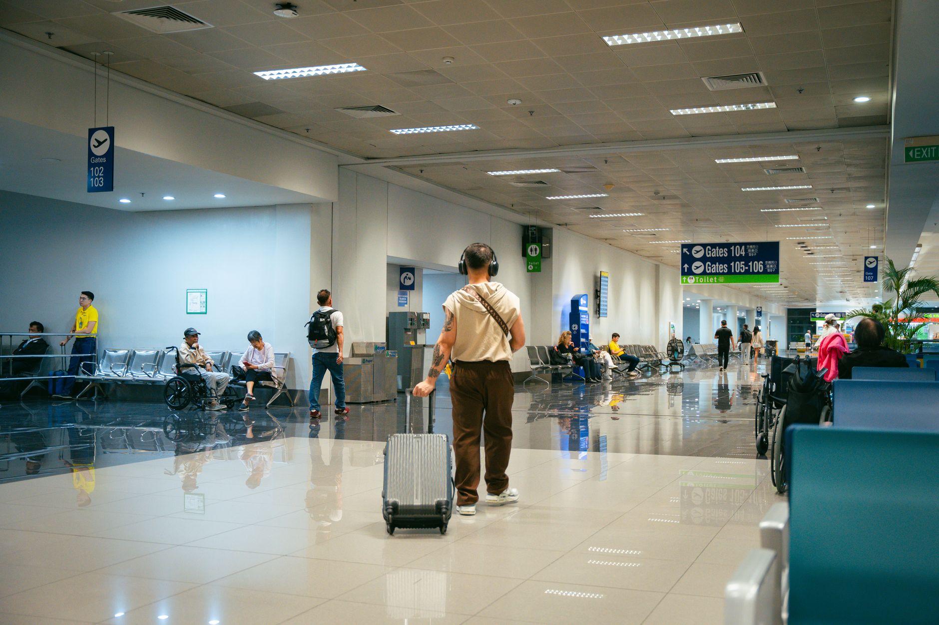 Busy airport interior showing travelers, seats, and signage for gates in Türkiye.