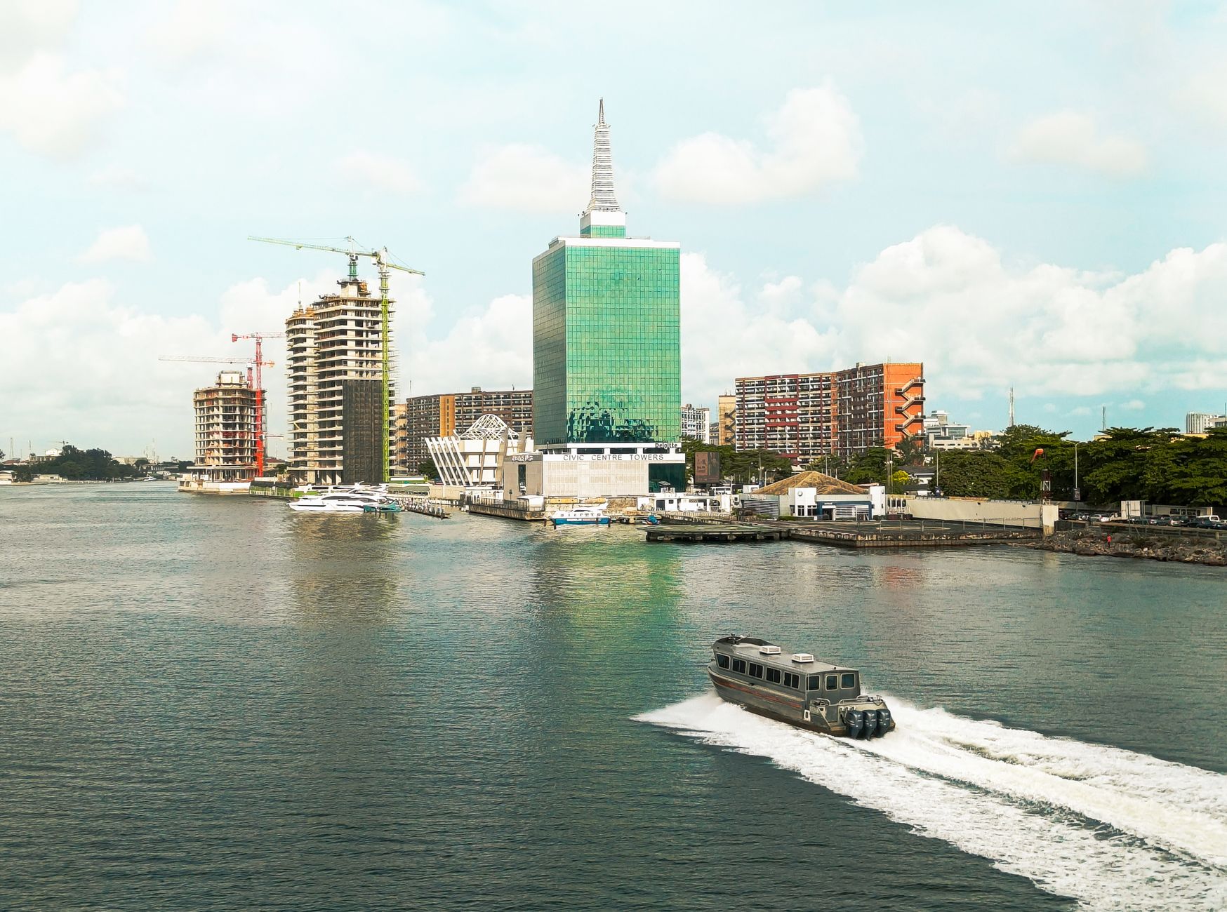 A view of Lagos' waterfront featuring skyscrapers and a boat in motion.