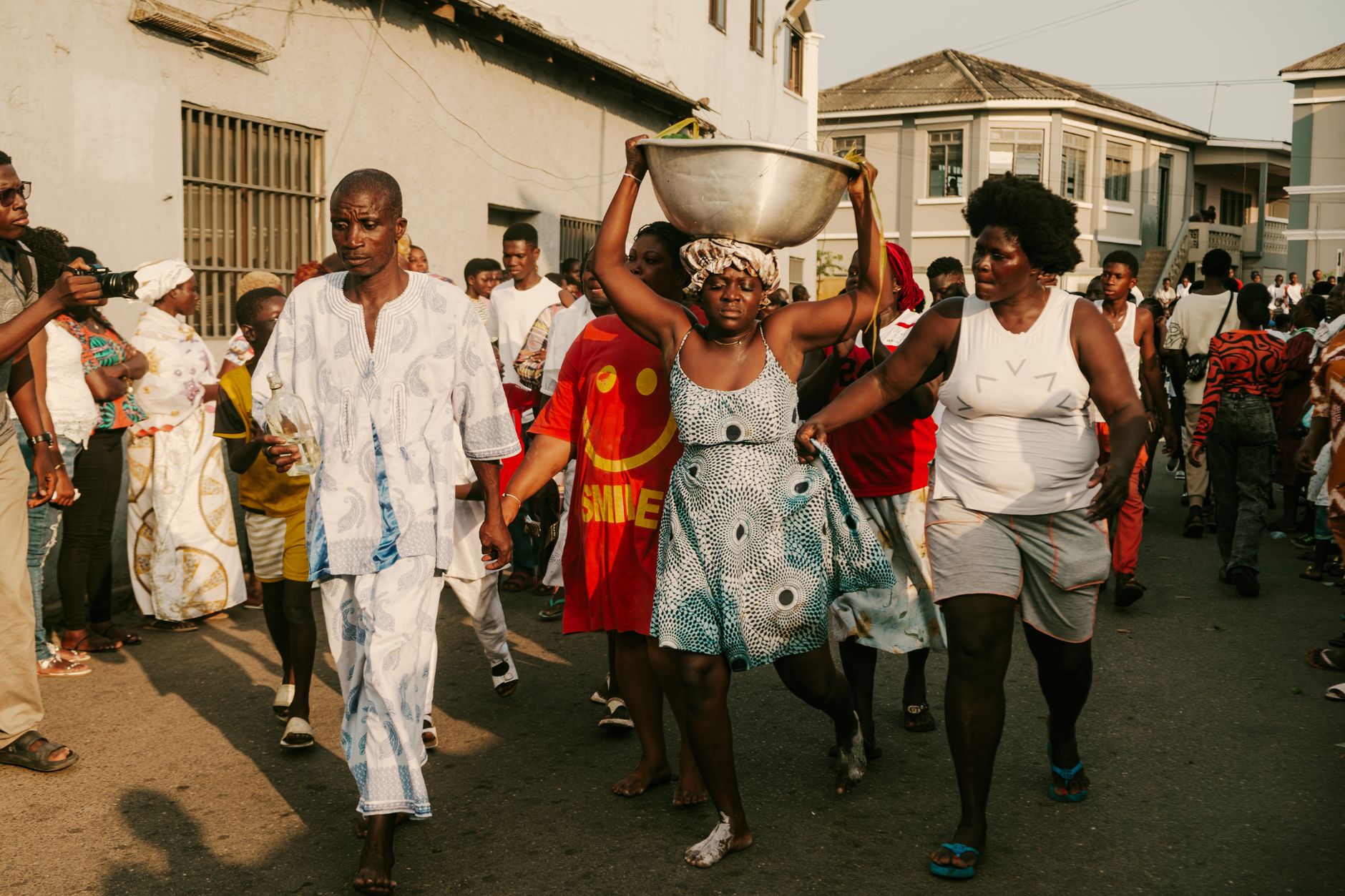 A busy street scene in a Central African city with locals participating in a cultural celebration.