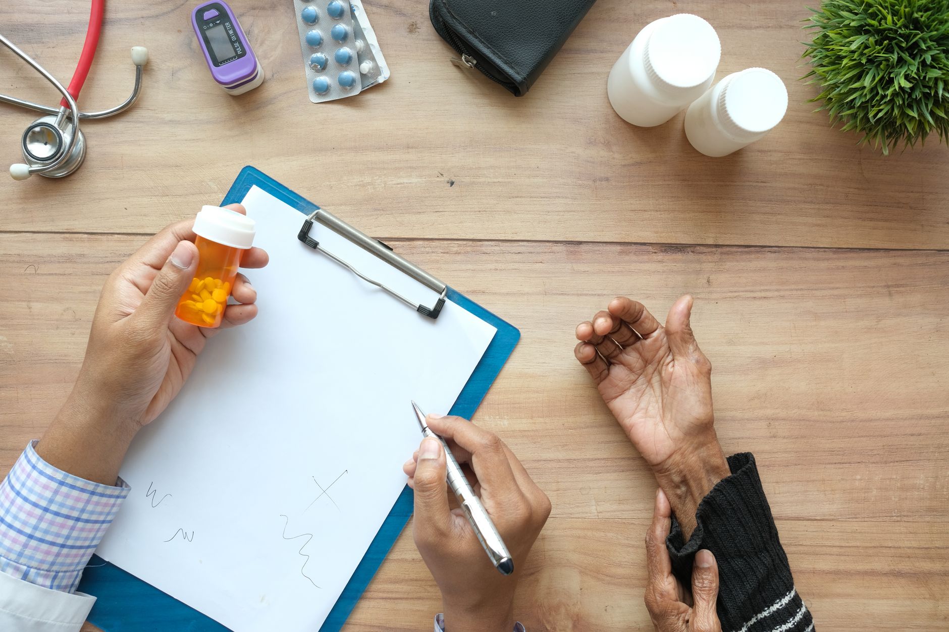 A healthcare professional discussing medication with a patient at a desk.