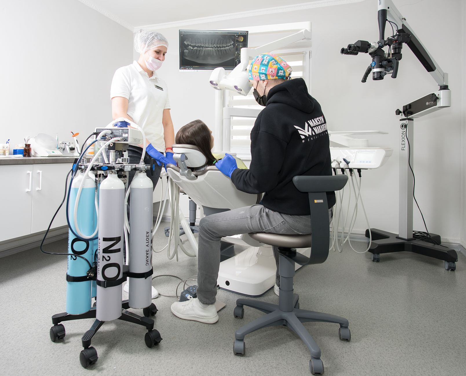 Anaesthesiologist administering sedation to a patient in a dental clinic.