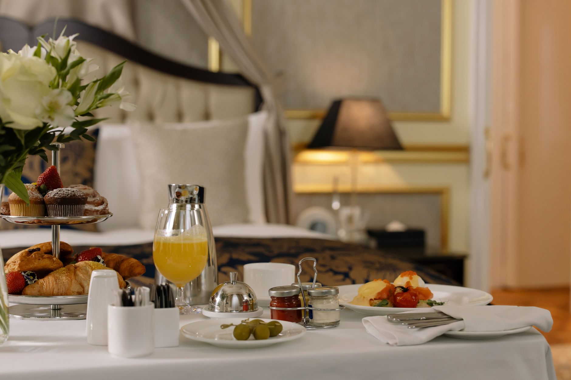 Luxurious breakfast spread in a hospital room, featuring pastries, fruit, and juice.