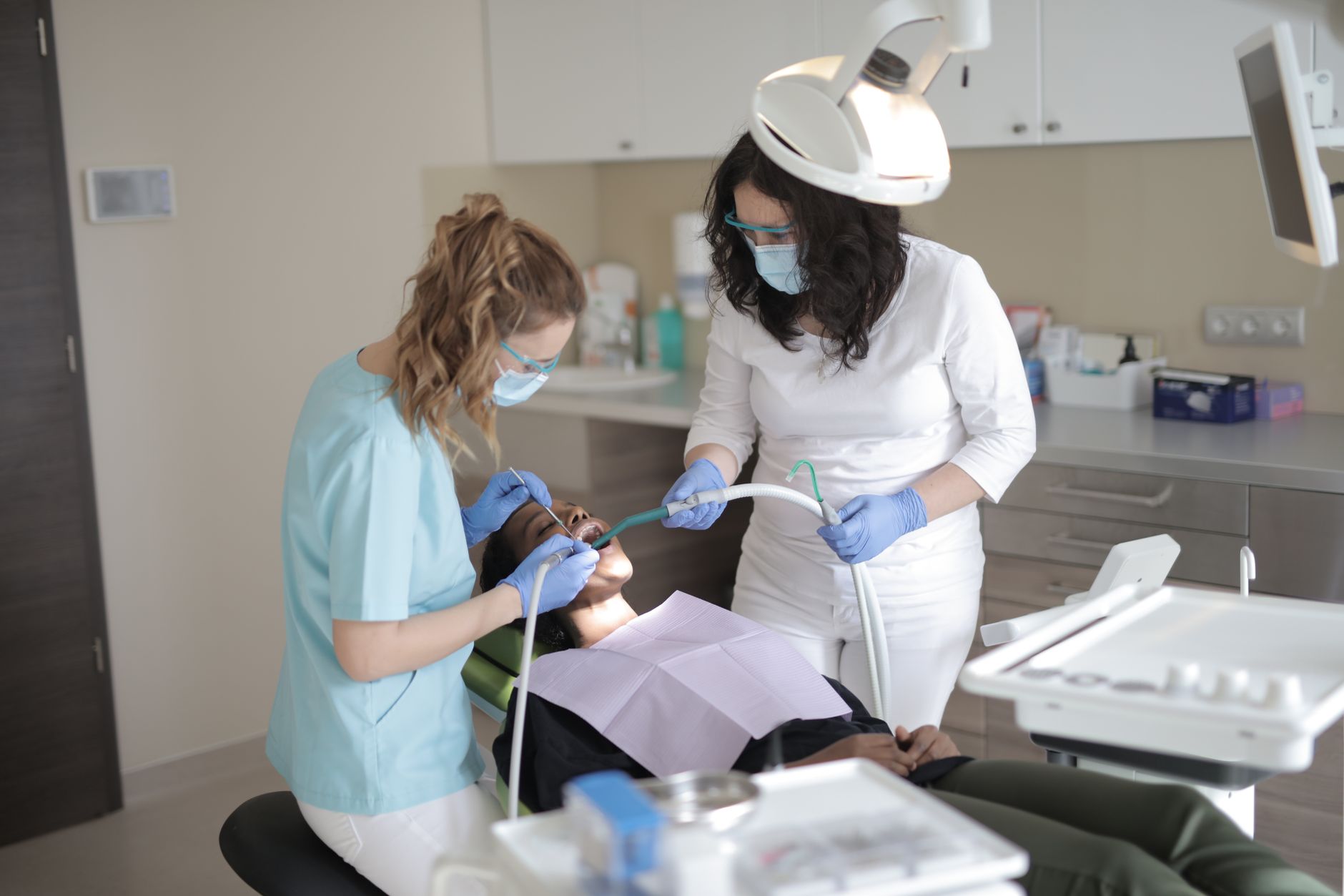 A dentist and assistant providing care to a patient in a dental office in Antalya.