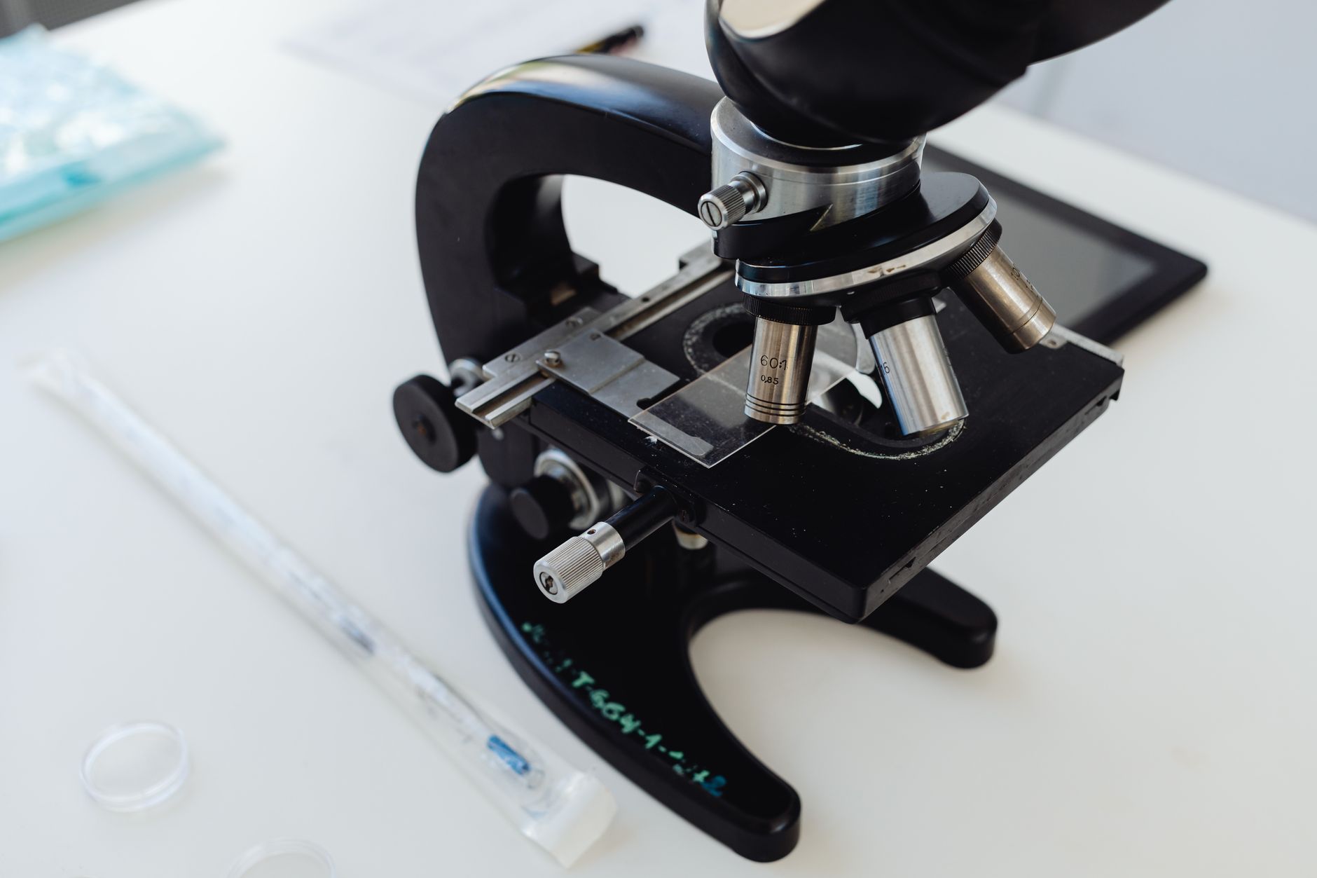 Detailed view of a microscope used for genetic screening in IVF, featuring various lenses and equipment.
