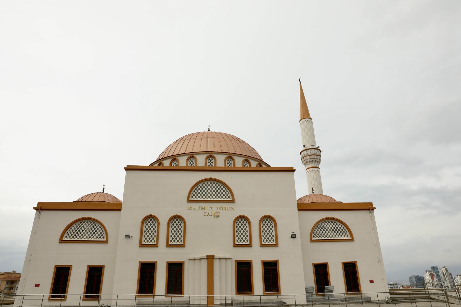 Exterior view of Mahmut Torun Mosque, showcasing its domes, minaret, and modern architecture.