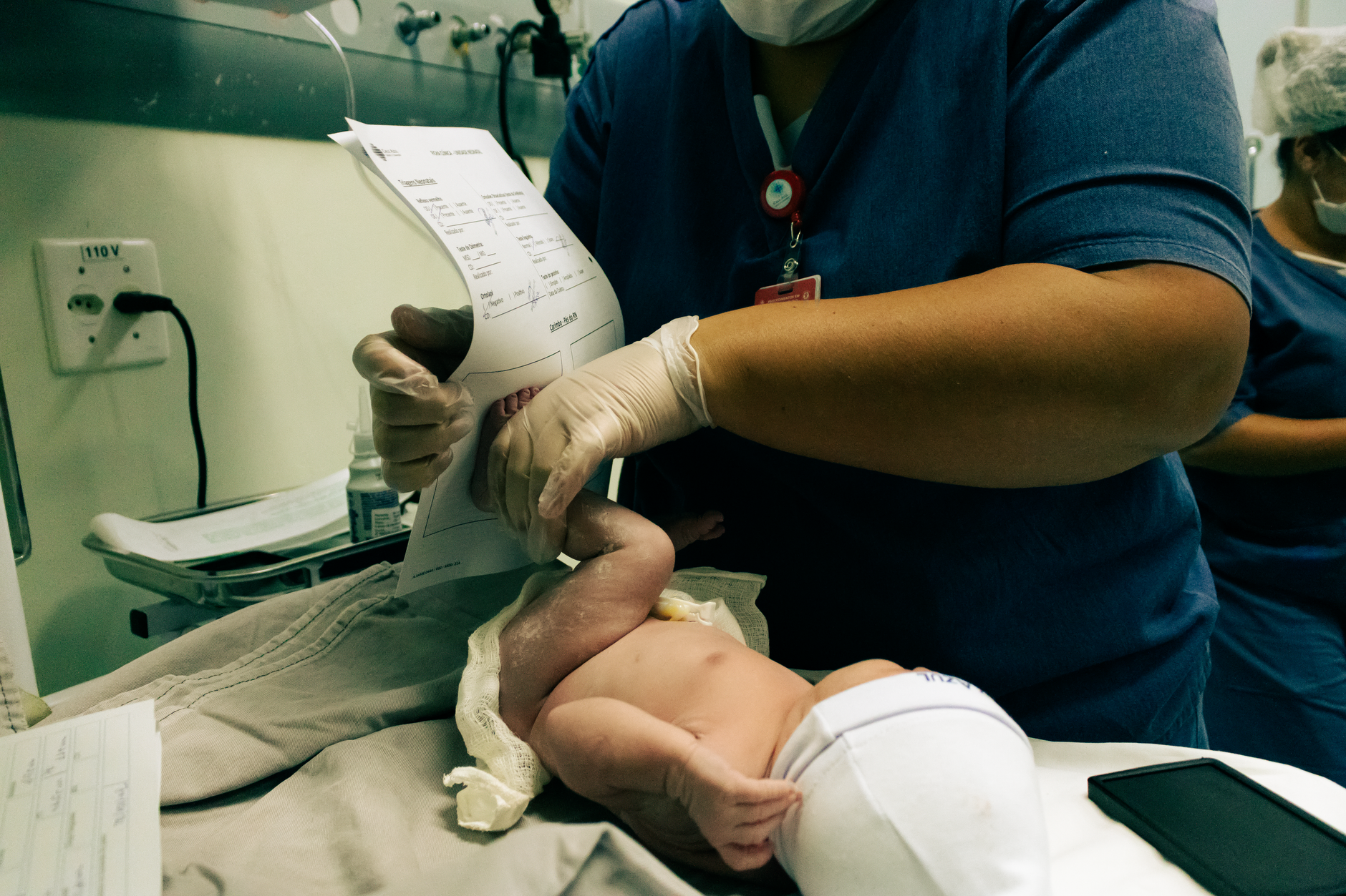 A nurse performs a procedure on a newborn baby in a hospital setting.