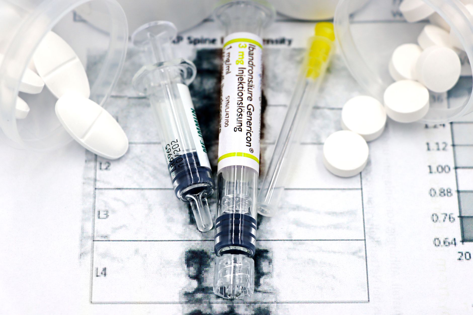 Syringes and tablets on a medical report related to wrist examination.