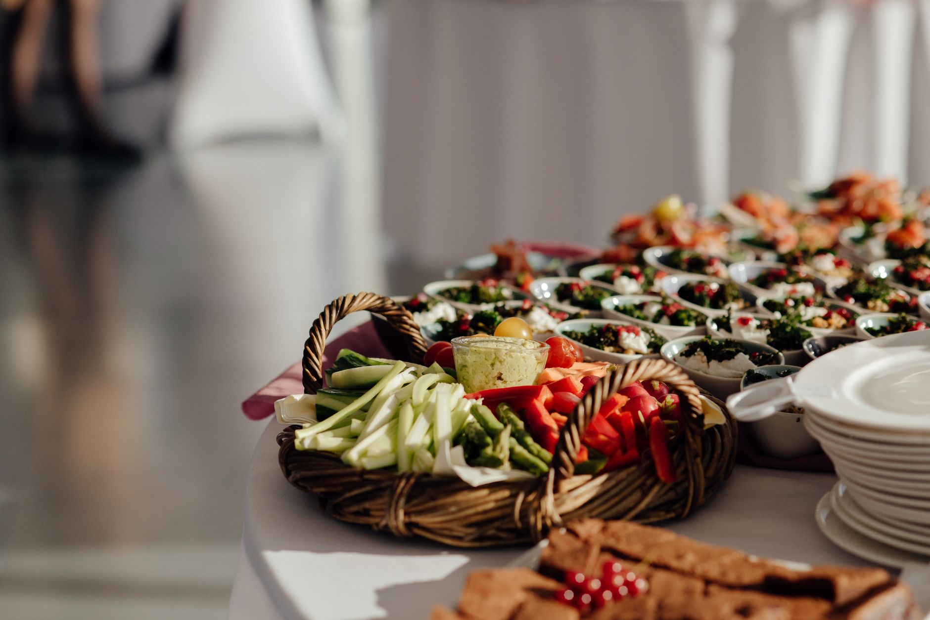 Fresh vegetable platter with various dips and garnishes at a stylish event.
