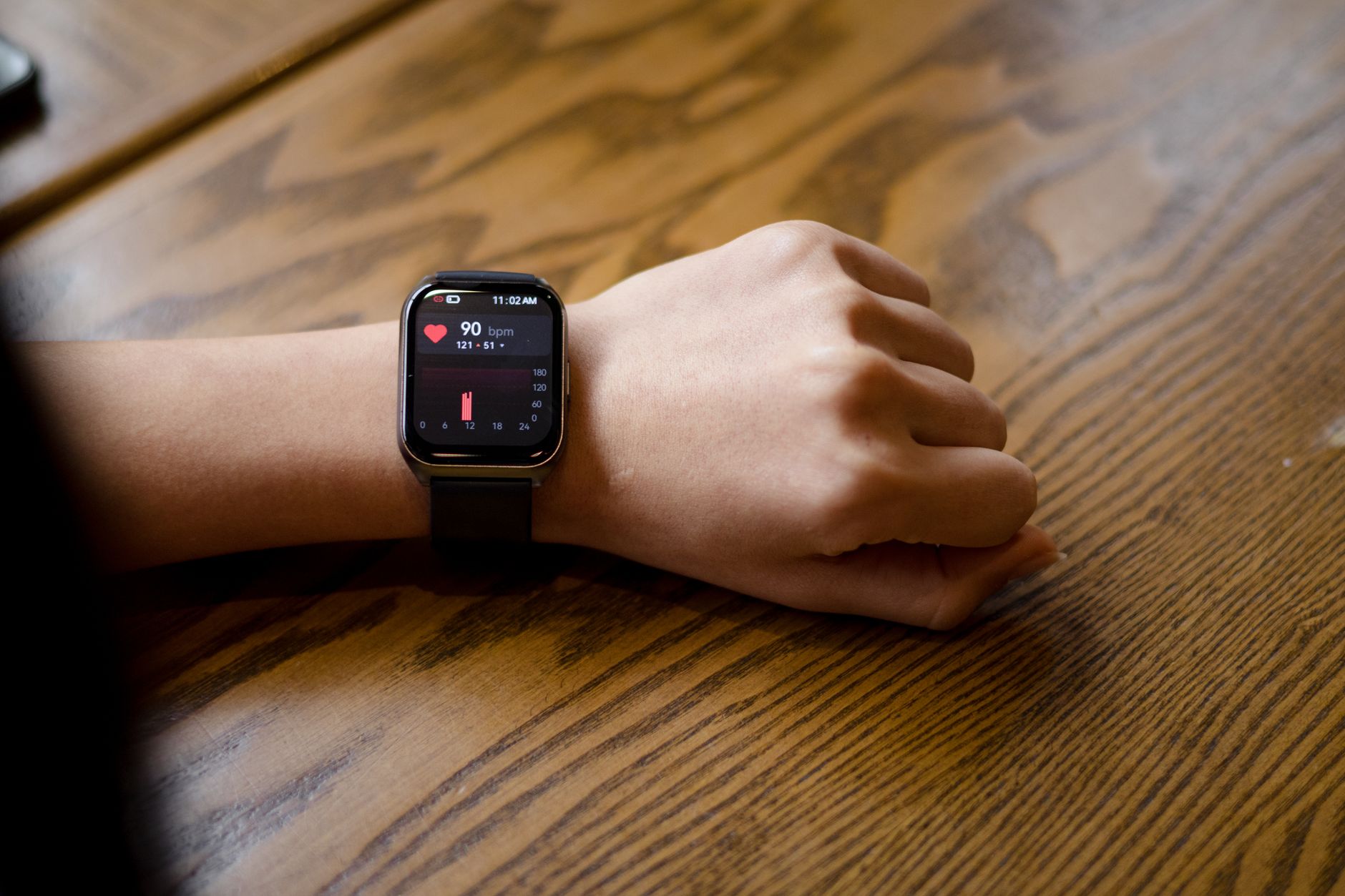 Close-up of a smartwatch displaying a heart rate of 90 bpm during exercise.