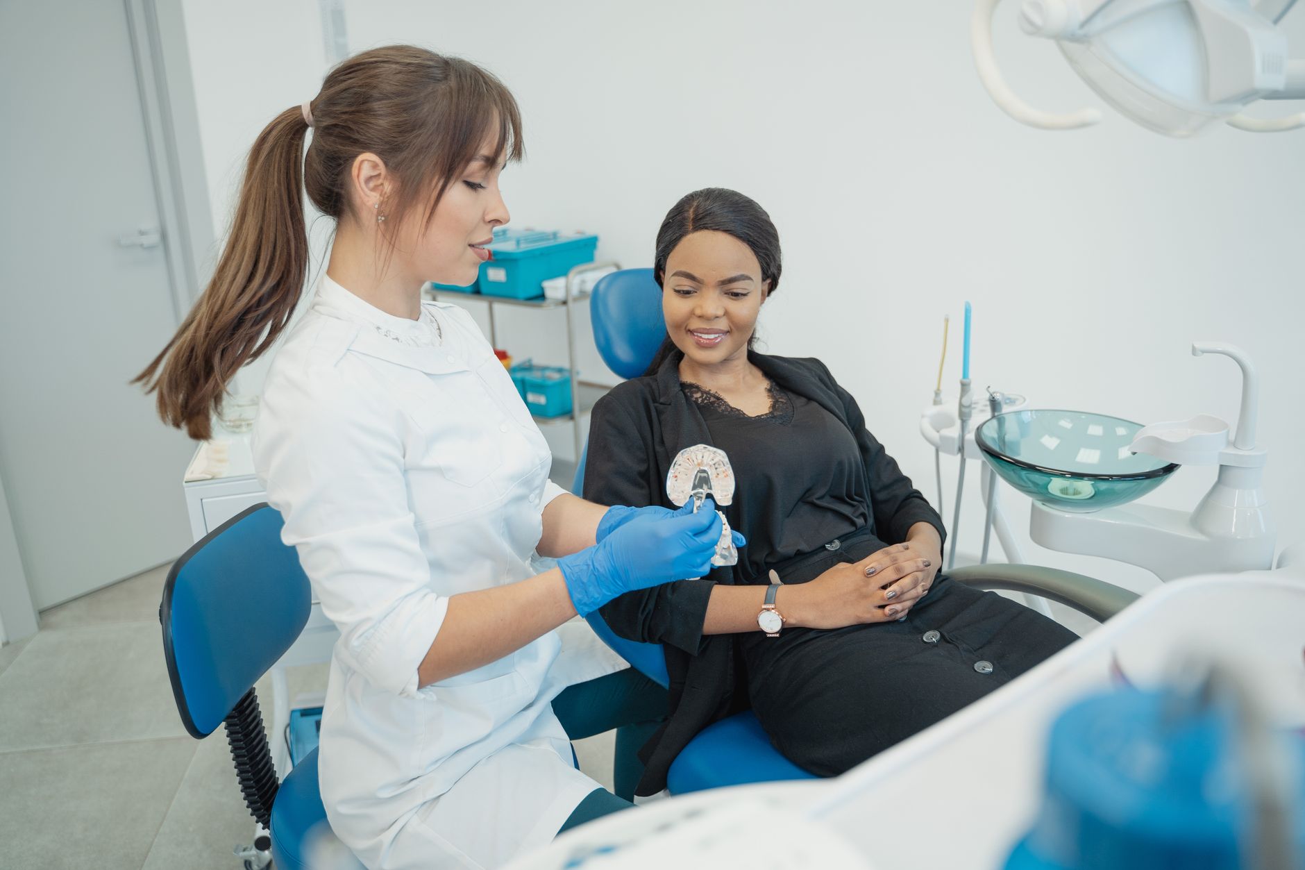 Nurse explaining dental care instructions to patient in clinic.
