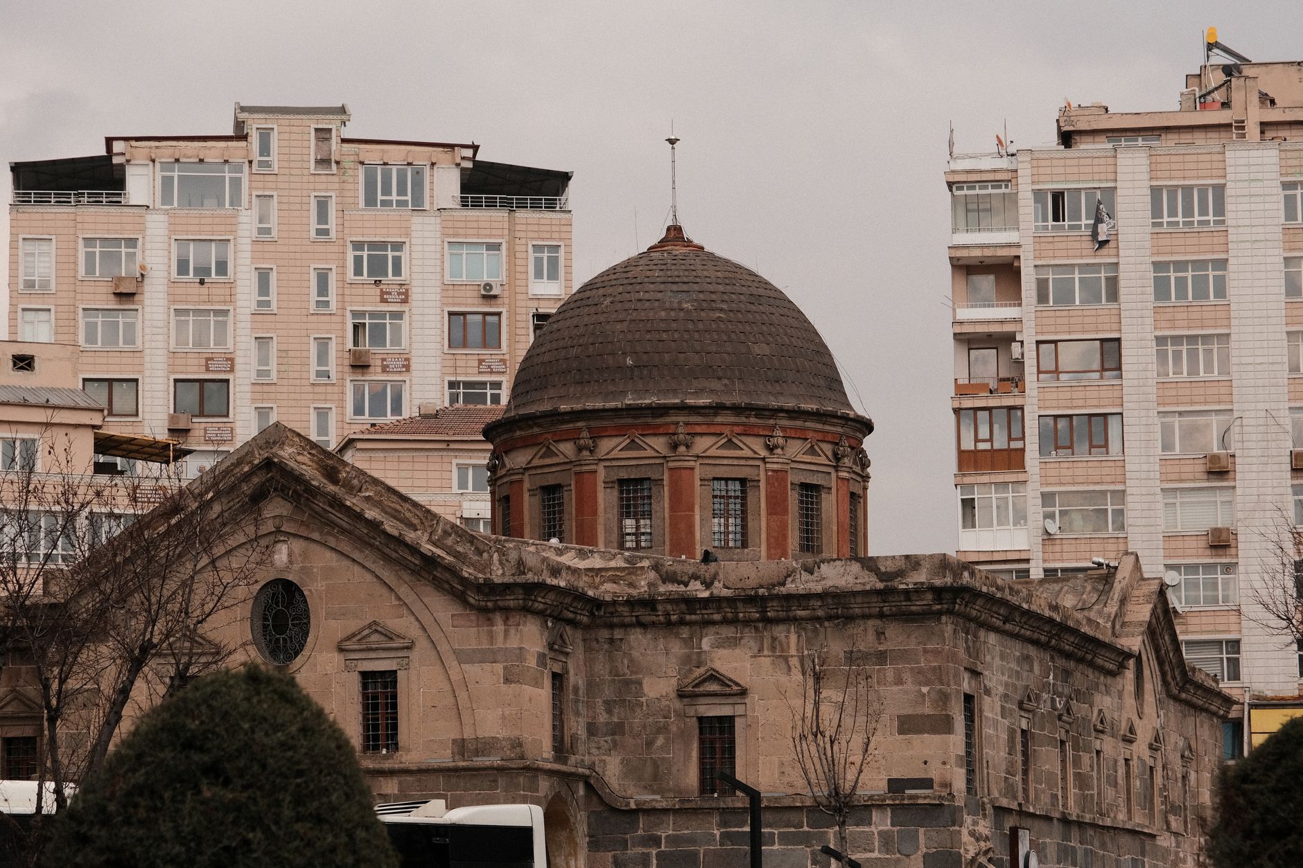 Image of a historical medical center with a dome, surrounded by modern buildings in Kayseri.