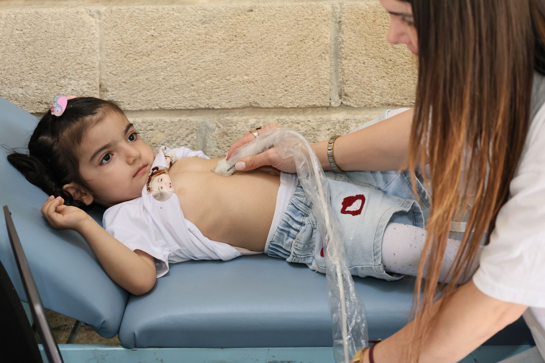 A child receiving an echocardiogram from a cardiologist, showcasing cardiac imaging on the ultrasound screen.