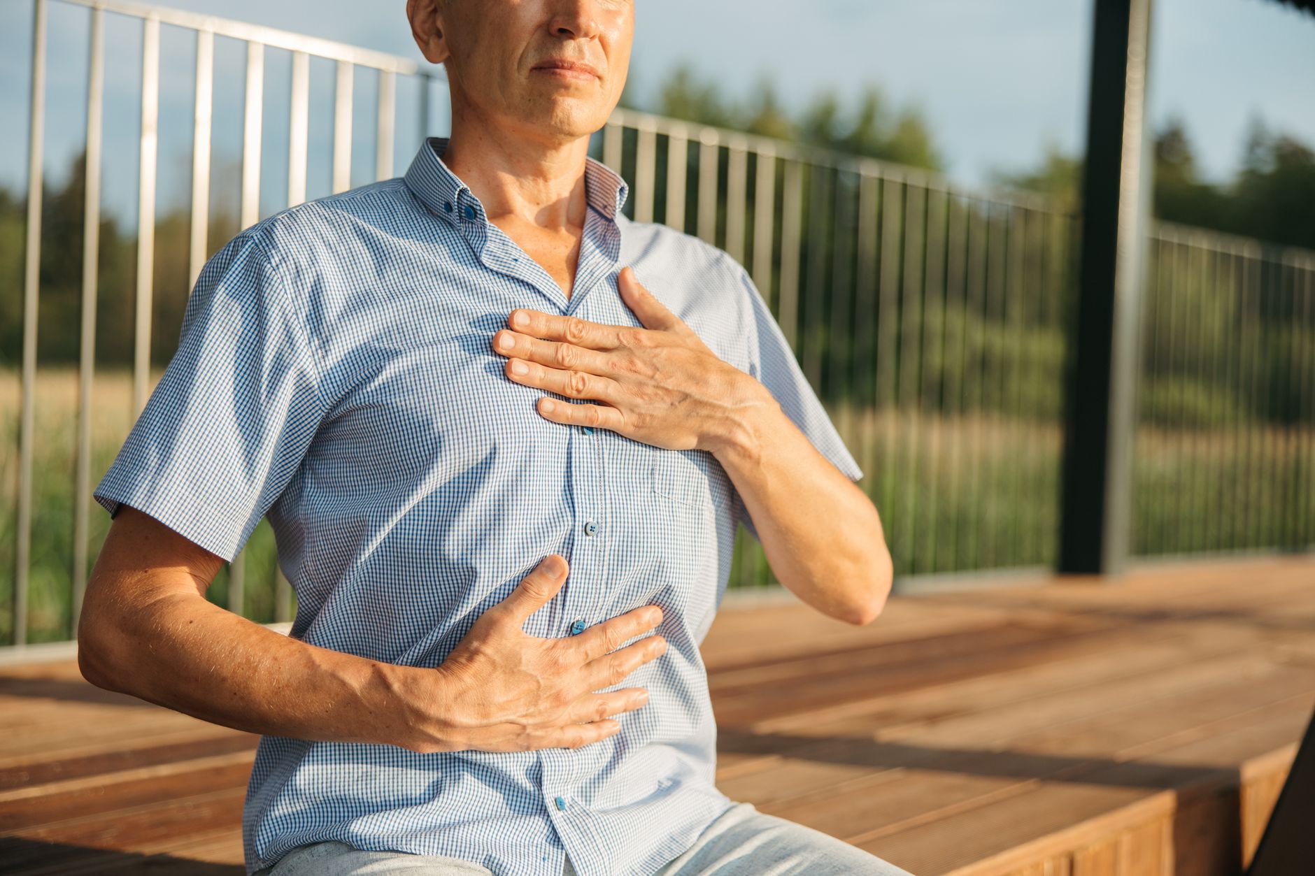A man outdoors practicing breathing exercises, focusing on his breath for cardiac prehabilitation.