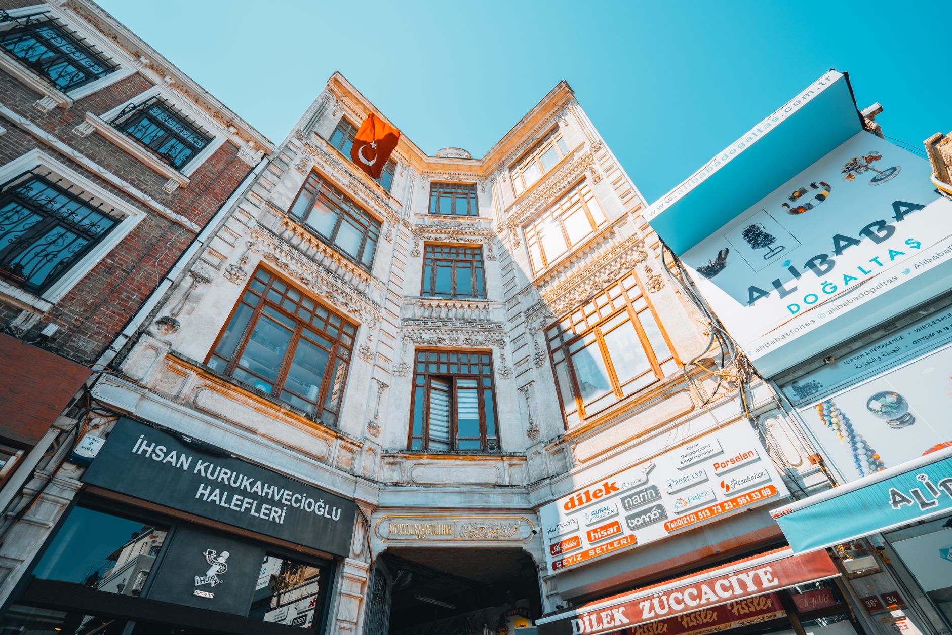 Historic architecture with a Turkish flag and local shops in Istanbul.