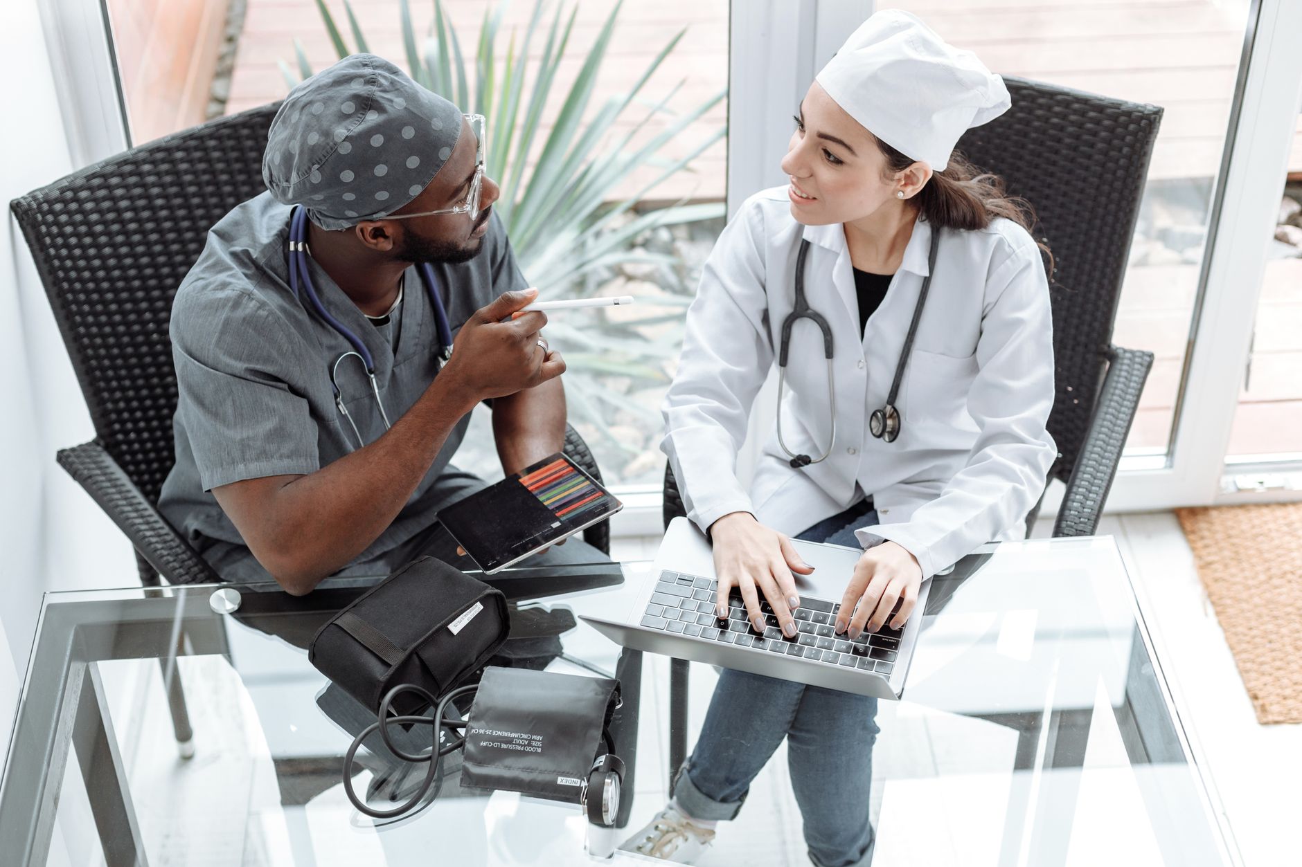 A doctor and nurse discuss patient care using a laptop and tablet in a Turkish hospital.