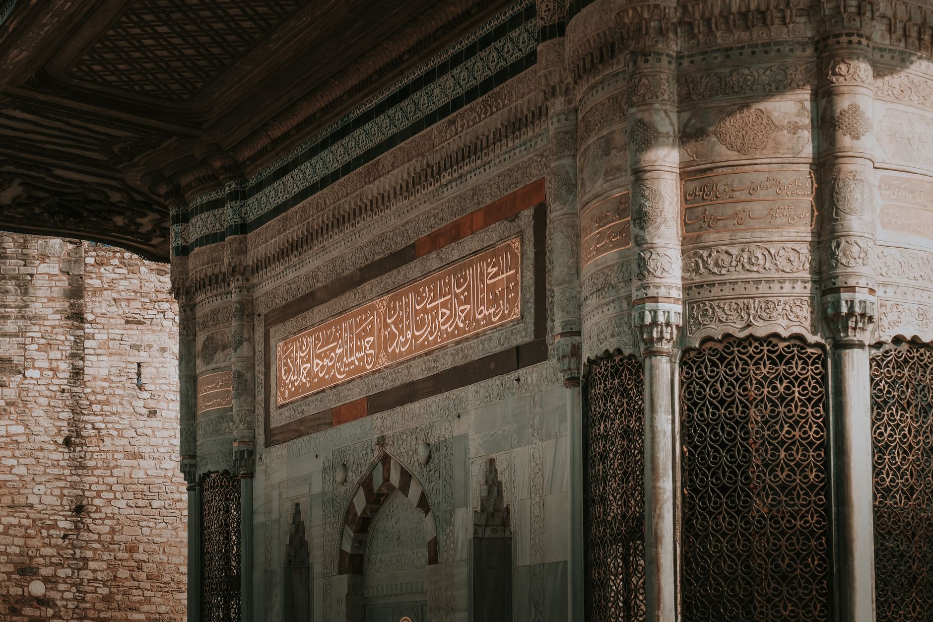 Interior of a Turkish hammam showcasing intricate marble designs and Arabic inscriptions.