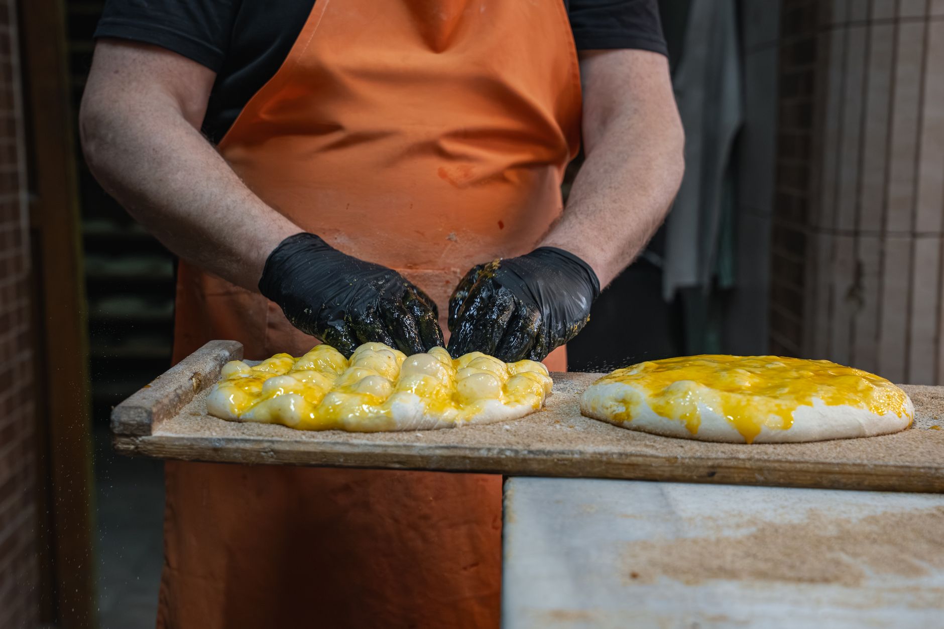 Close-up of hands preparing kuymak with cheese and egg in a kitchen.