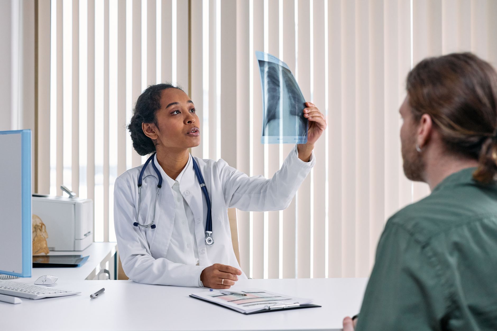 A doctor showing an X-ray to a patient during a medical consultation.