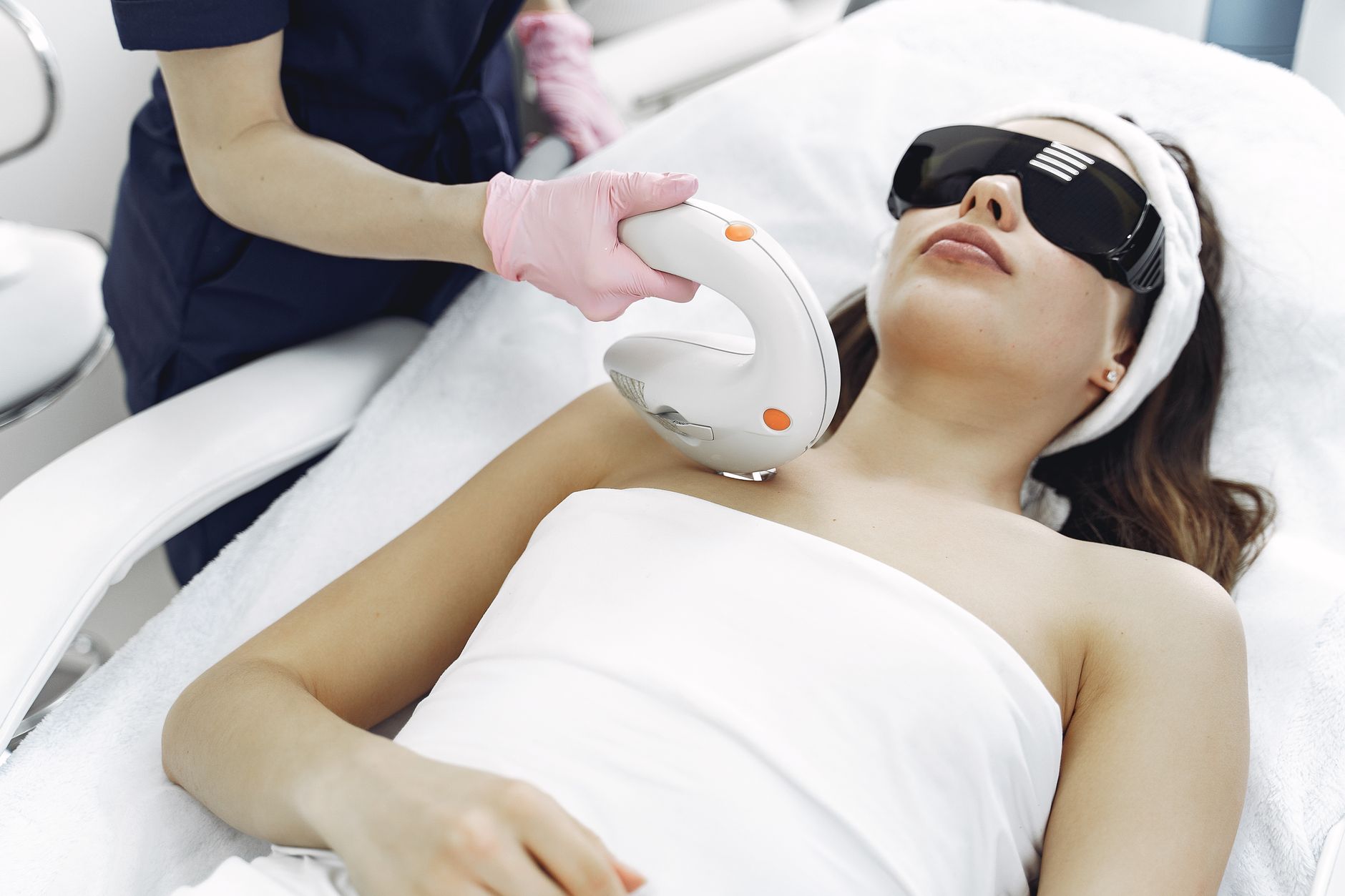 Dermatologist using a fractional laser device on a patient's chest area.