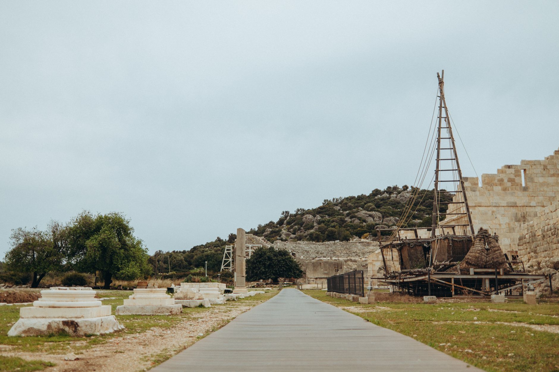 Pathway in Bodrum Castle with ancient ruins and a wooden shipwreck on display.