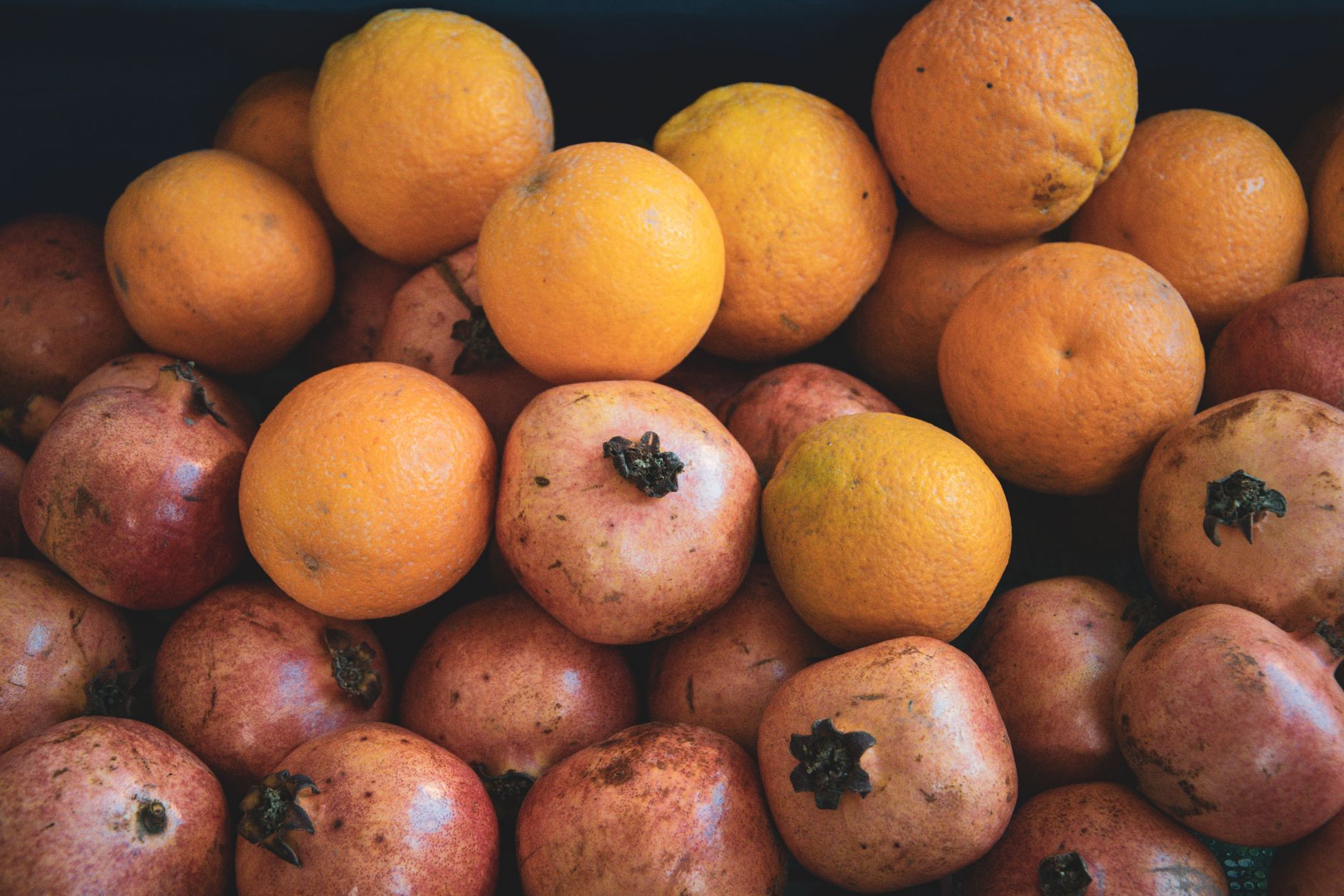 Яркая витрина с апельсинами и гранатами на рынке в Анталье.