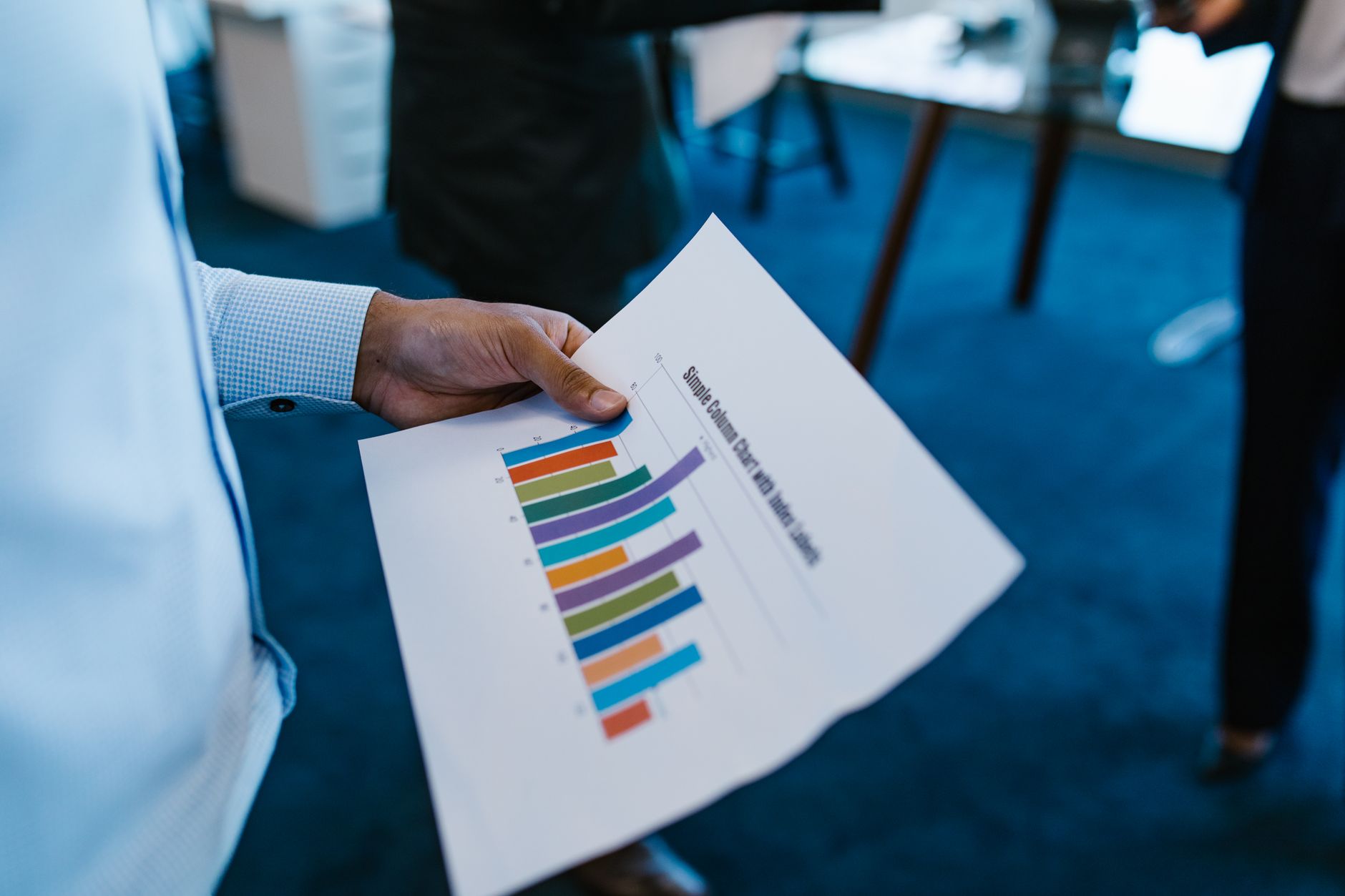 A doctor holds a report with colorful bar charts during a presentation.