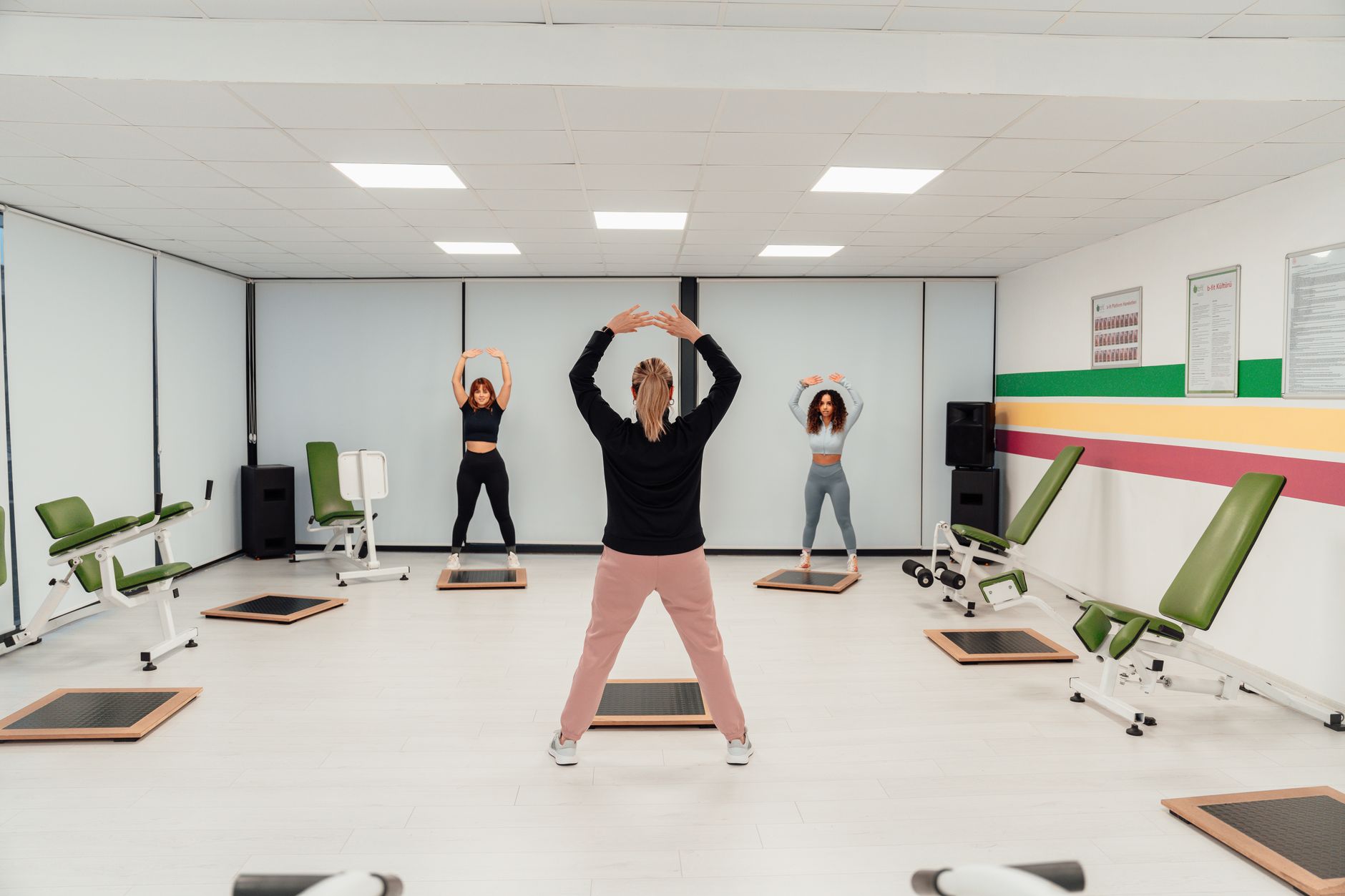 Group of individuals participating in guided gentle exercises in a gym.