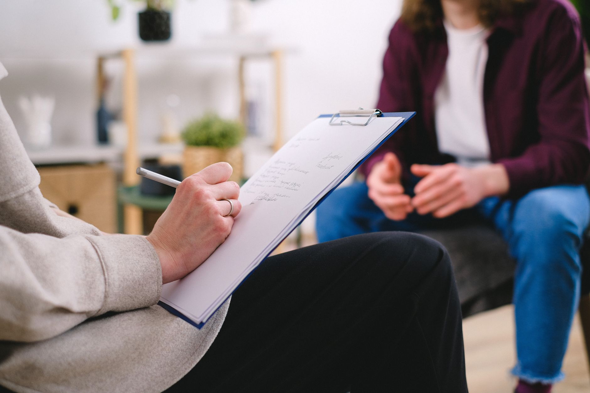 A person taking notes during a behavioral support session for bariatric care.