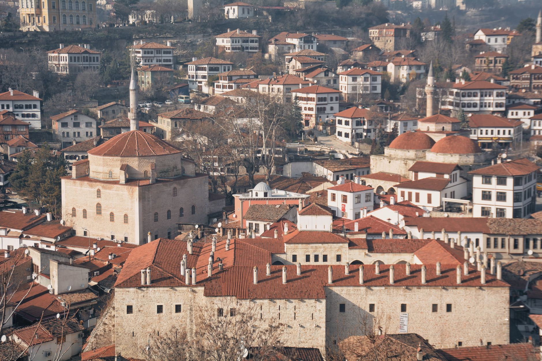 Snowy view of Ottoman houses in Safranbolu, featuring a historic hamam nearby.