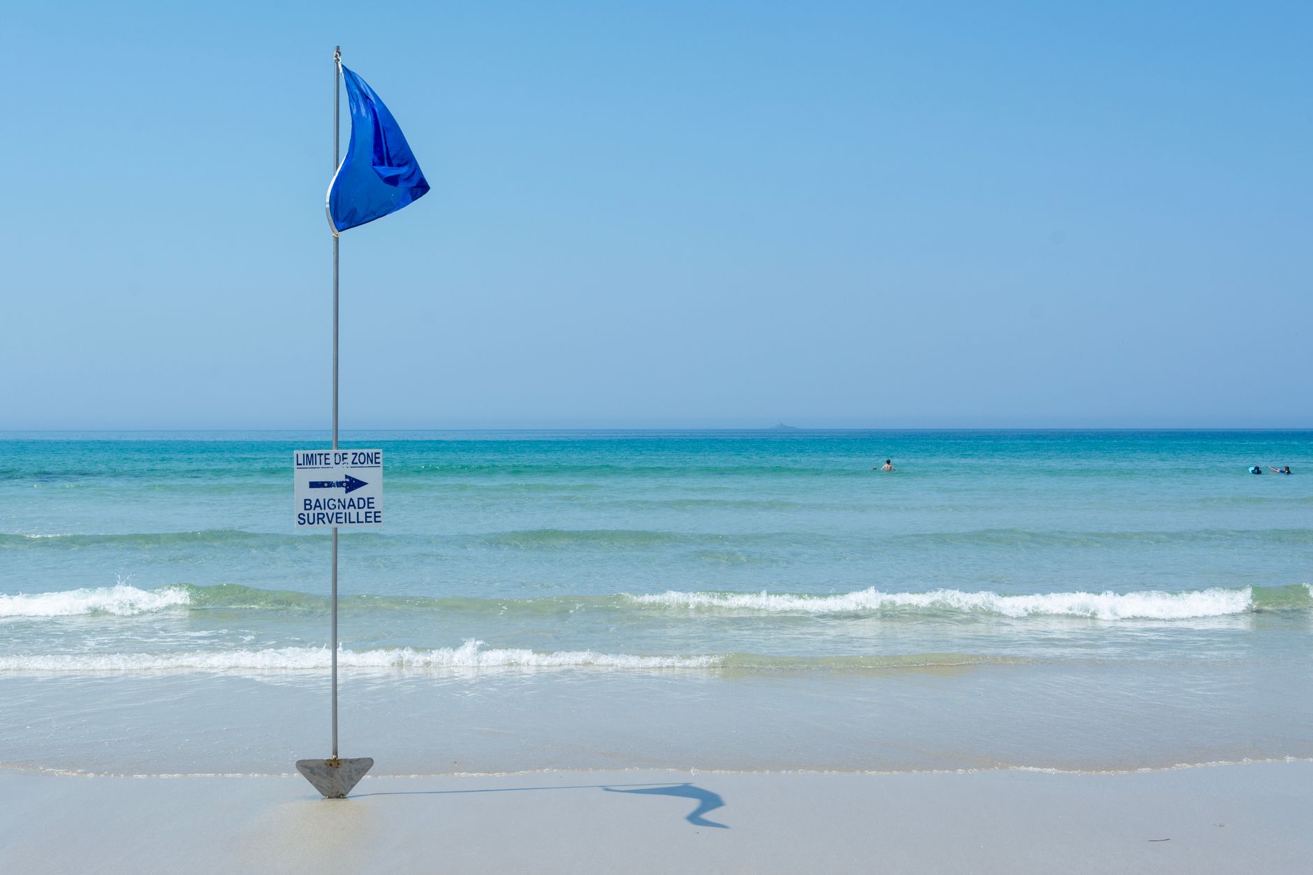 Close-up of a Blue Flag award sign indicating a monitored swimming area on a Turkish beach.
