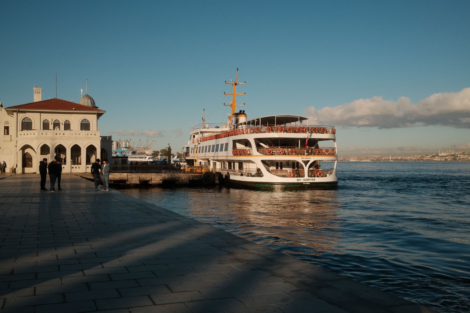 A ferry named 'SH-SARIYER' docked at a waterfront pier in Istanbul.