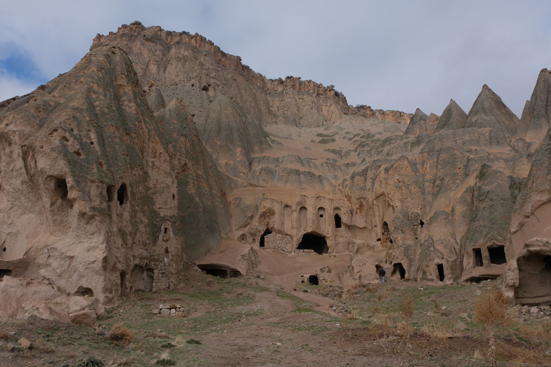 یک پناهگاه غاری روستایی در کوه‌های توروس، احاطه شده با سازندهای صخره‌ای طبیعی.