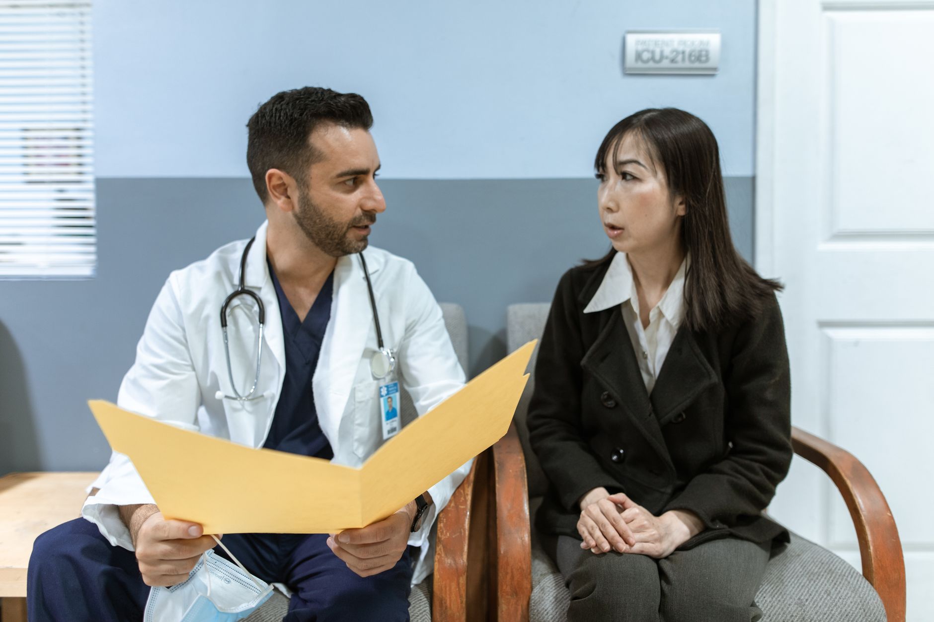 A doctor talks with a patient in a clinic, discussing treatment options.