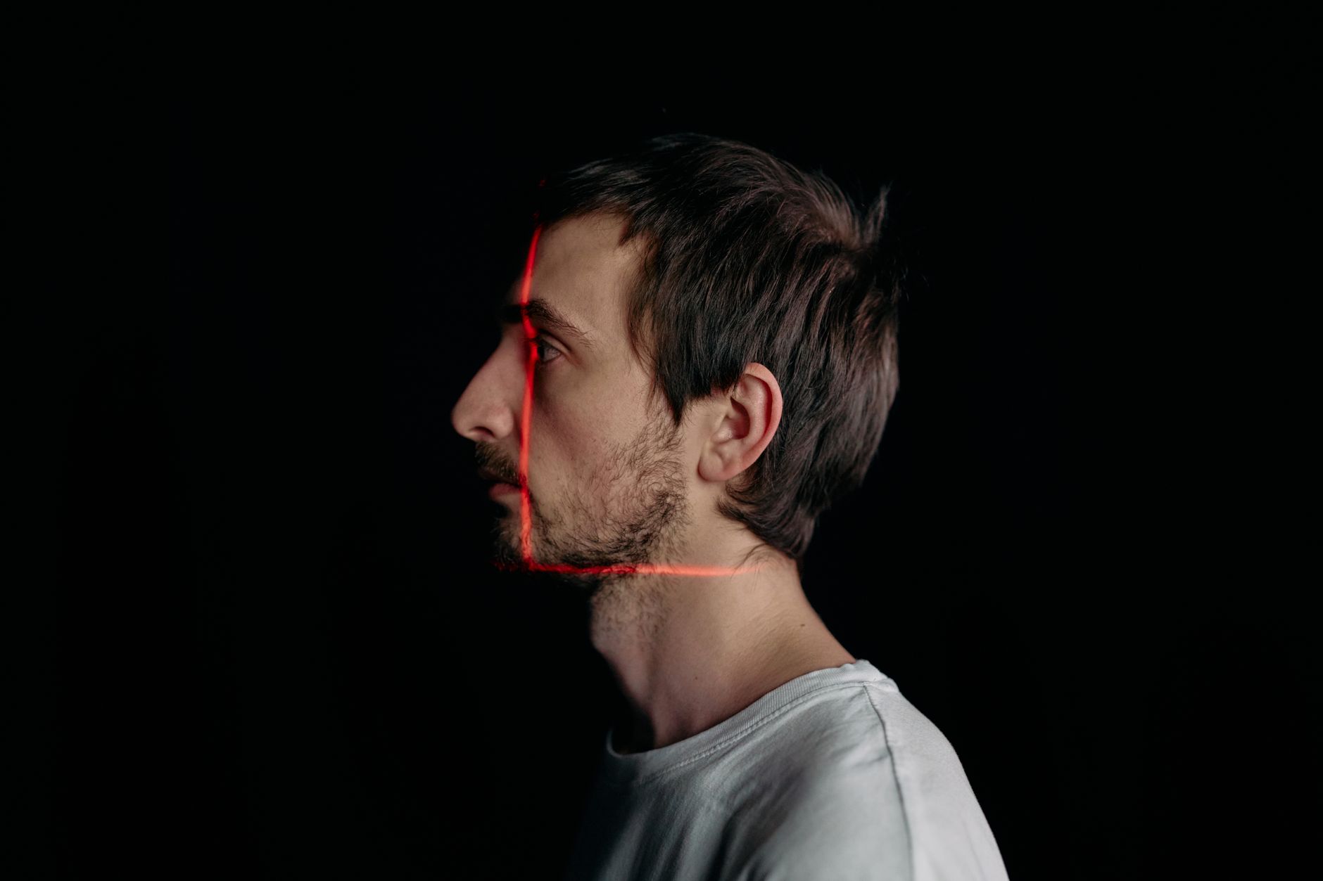 Profile of a man captured with a red laser during 3D scanning.