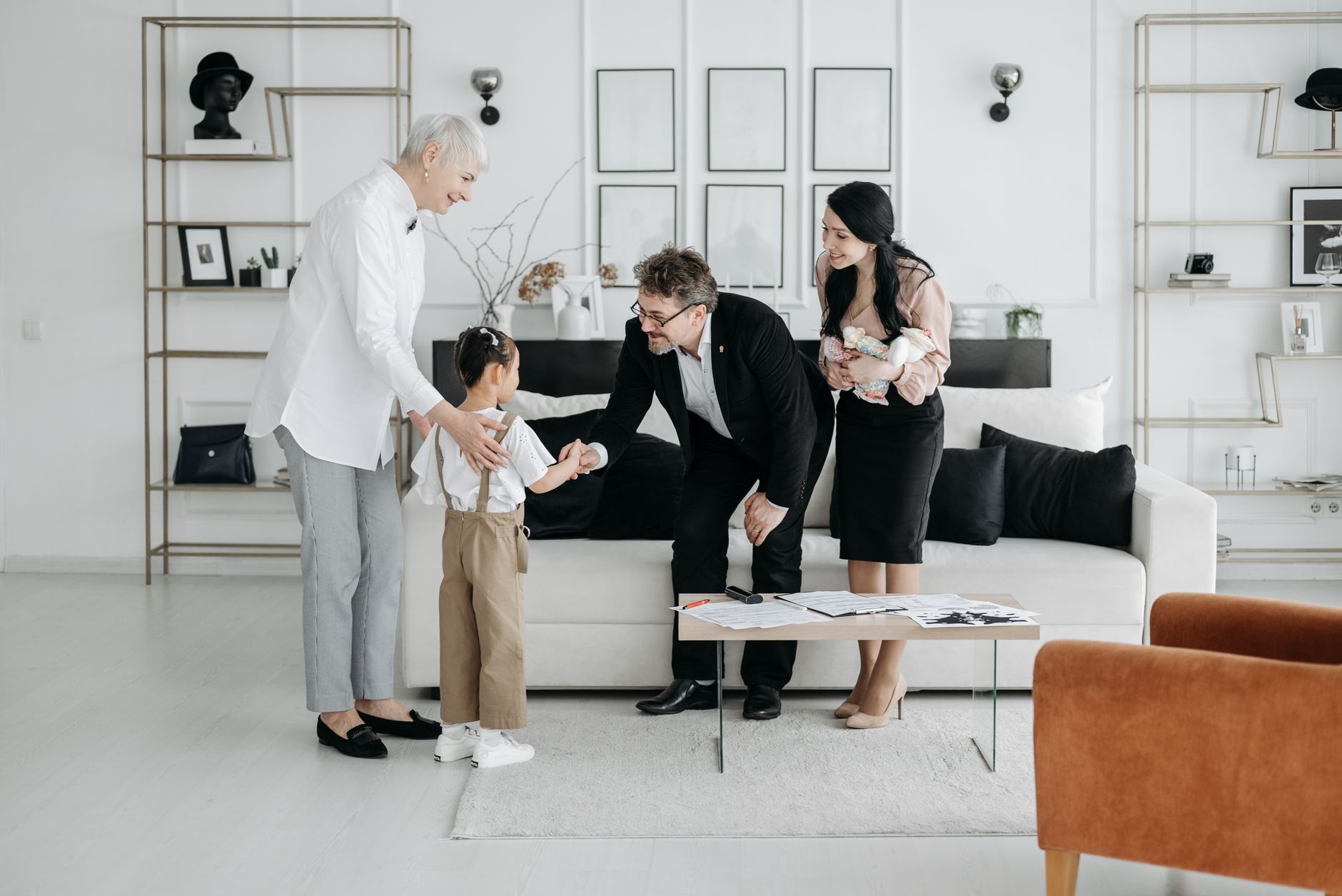 A multidisciplinary team meets with a family in a stylish living room, discussing care planning and follow-up resources.