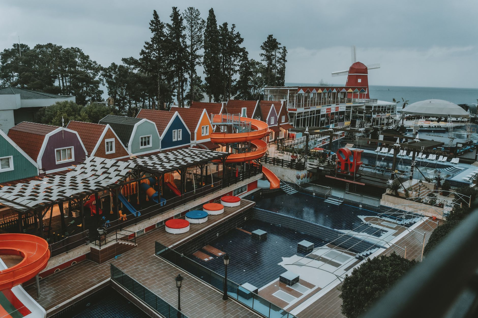 Aerial view of a vibrant recovery resort in Antalya featuring colorful houses and a water slide.