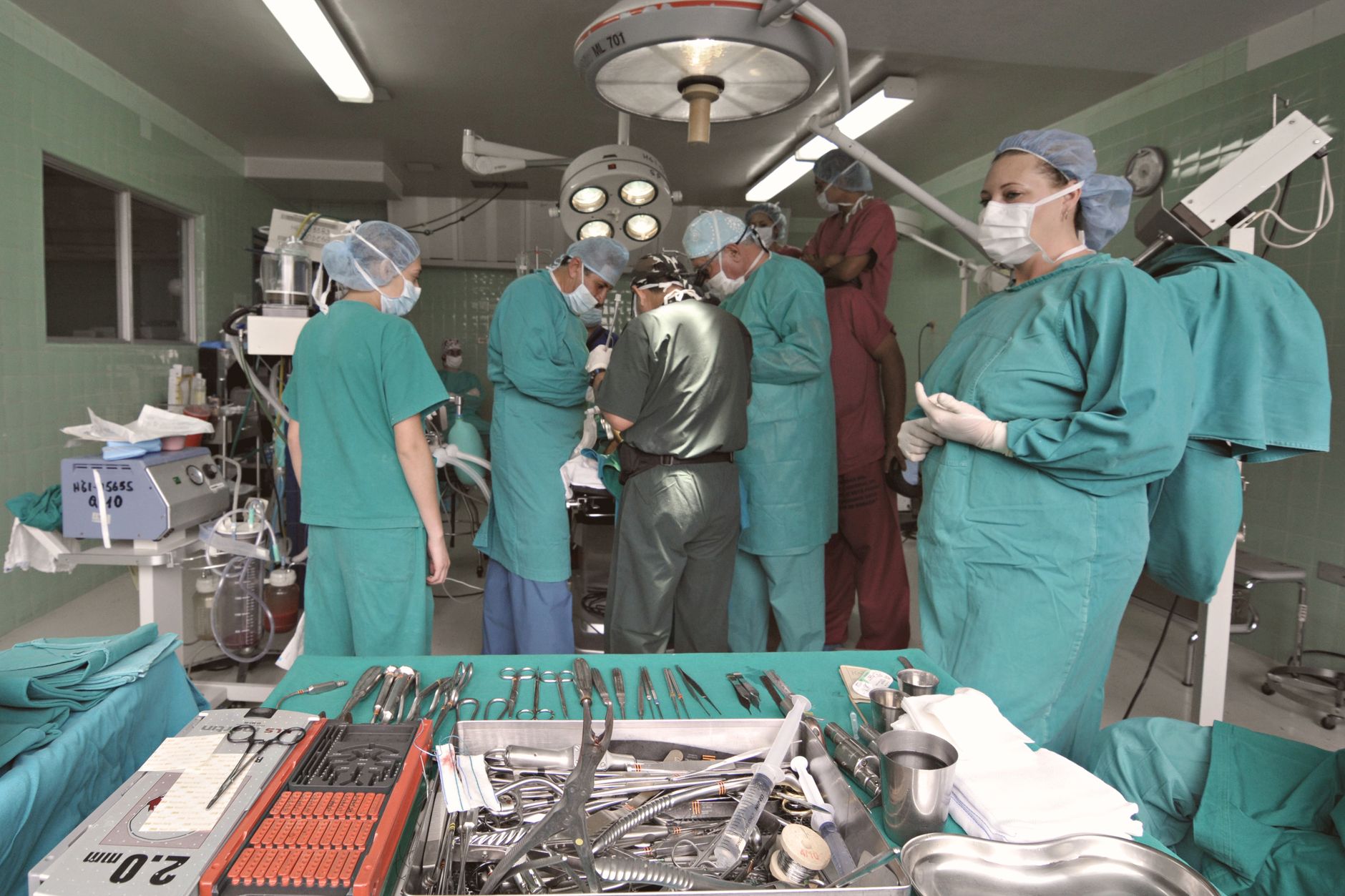 Surgical team working in an operation room with various tools and medical equipment.