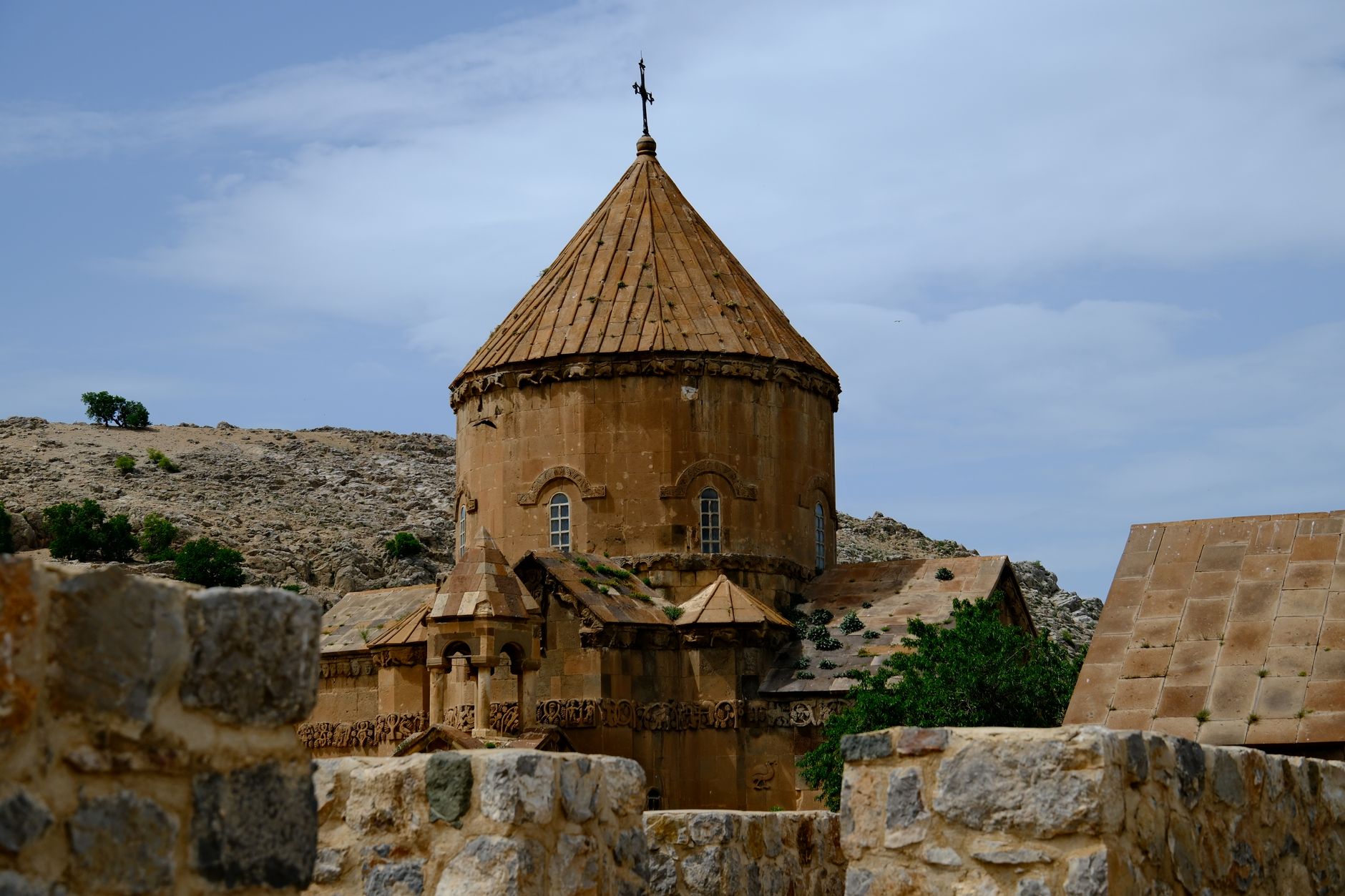 كنيسة أقدامار بقبتها المميزة وعمارتها الحجرية تطل على المناظر الطبيعية الجبلية.
