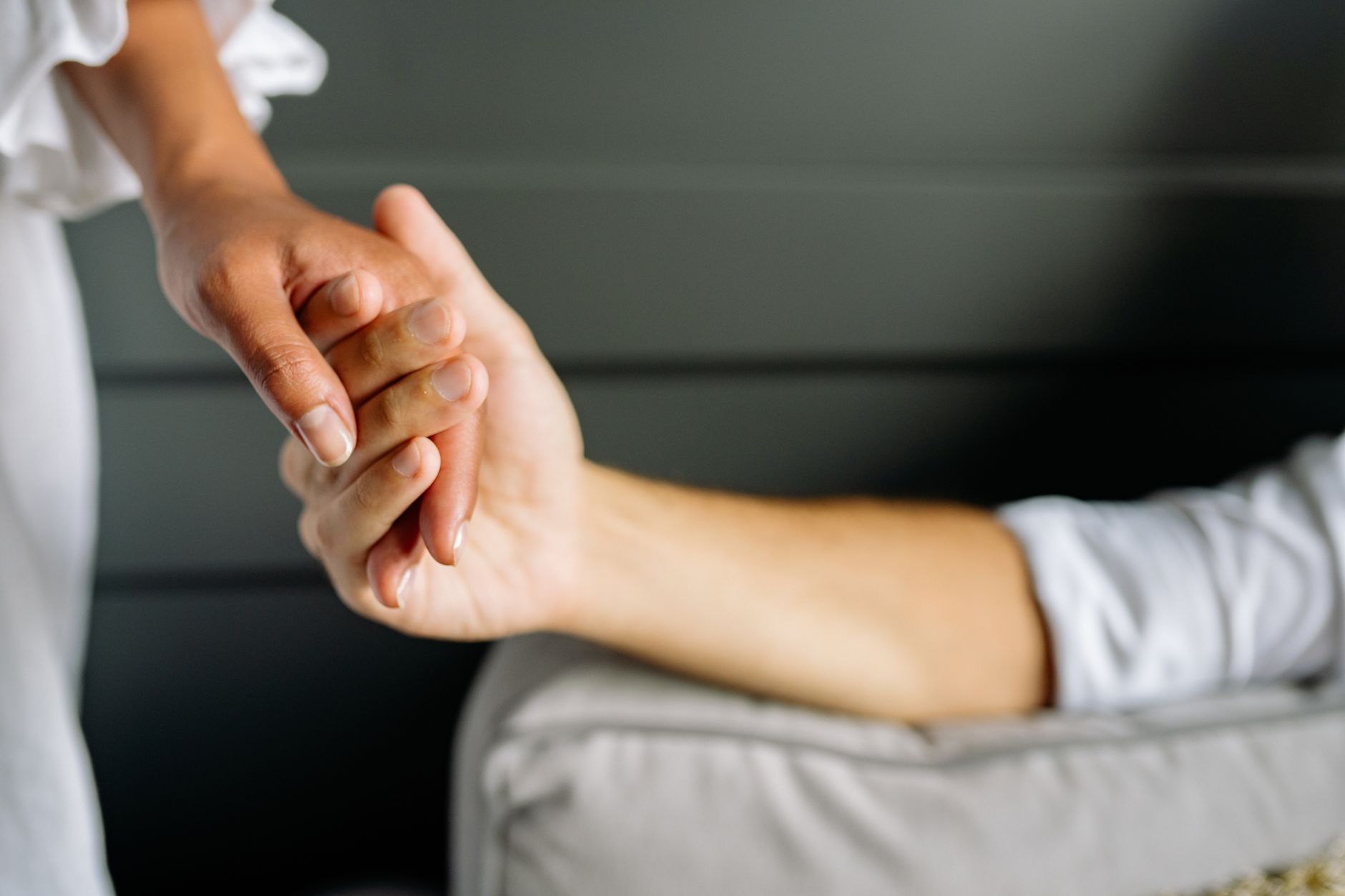 Close view of two hands holding tightly, indicating tremor symptoms.