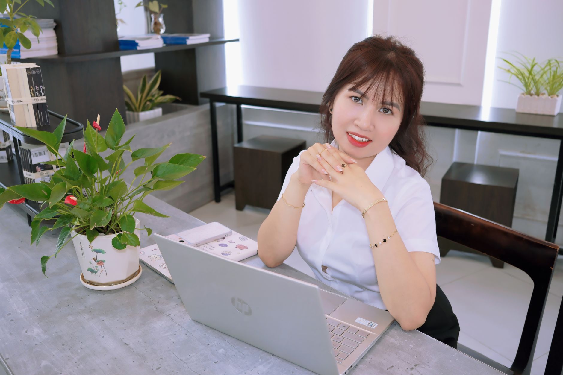 A dentist in a sleek office demonstrates a digital smile design on a laptop.
