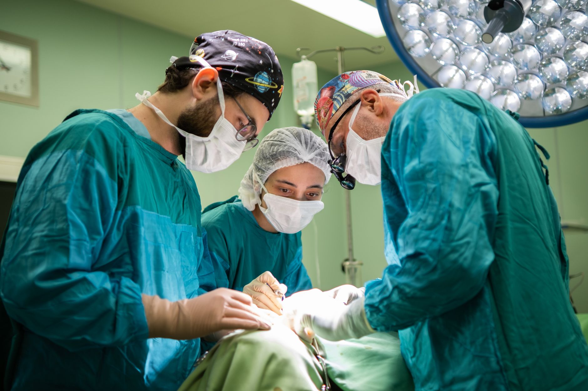 A surgical team in scrubs and masks focused on a procedure in a hospital.
