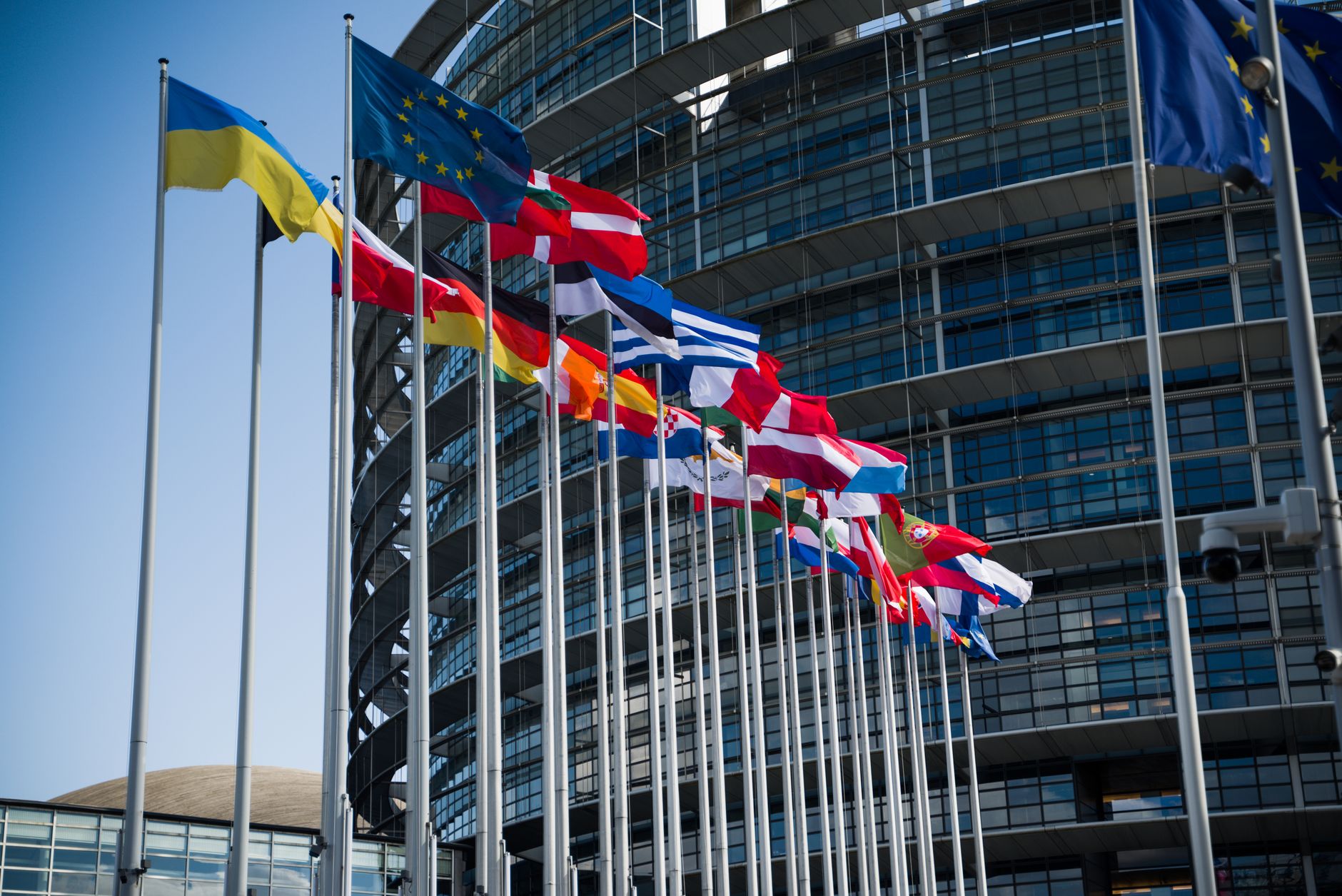 Flags of various countries outside the European Parliament in Strasbourg, symbolizing international cooperation.