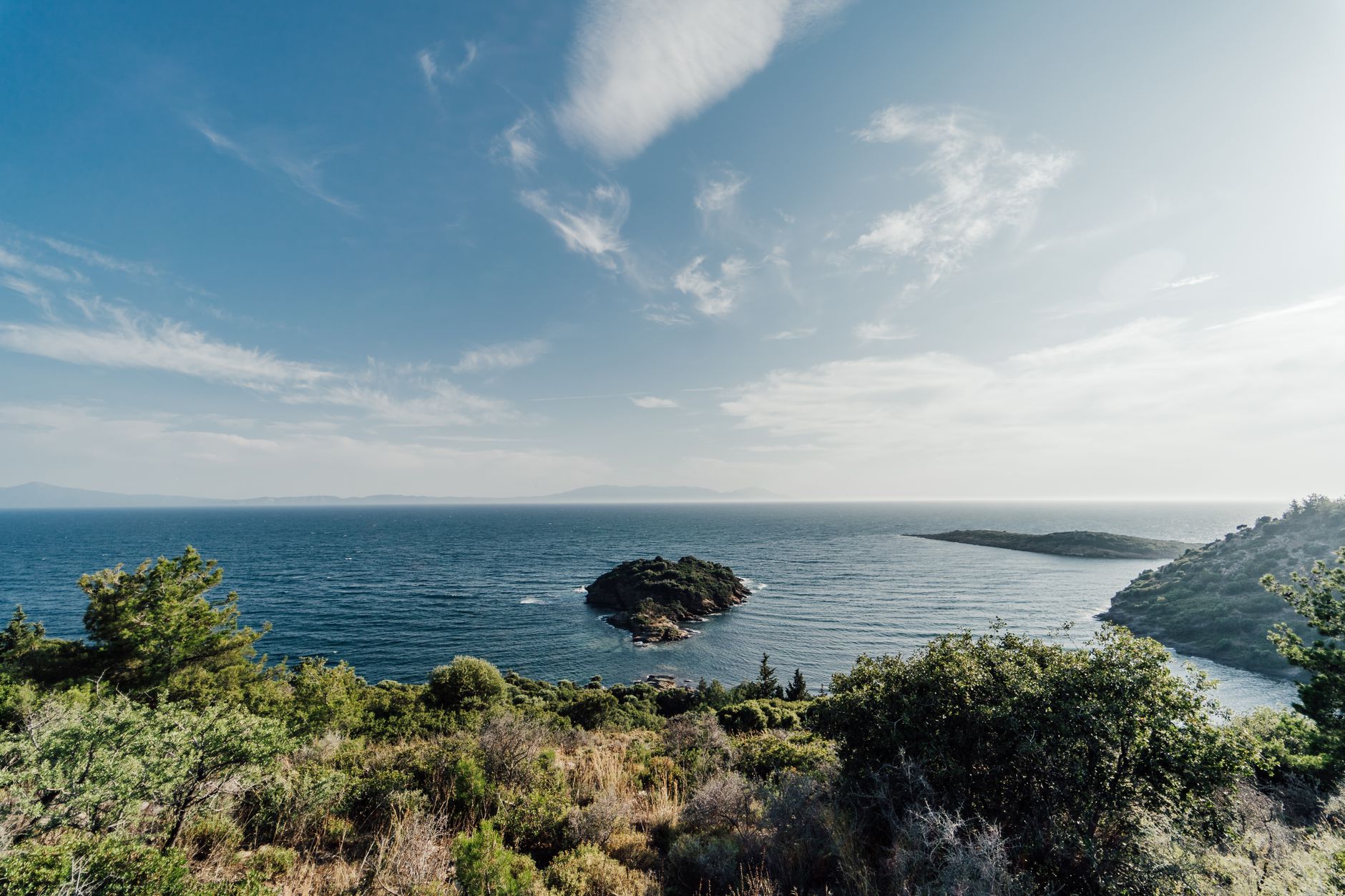 A panoramic view of the coastline in Datça featuring clear blue water and lush greenery.