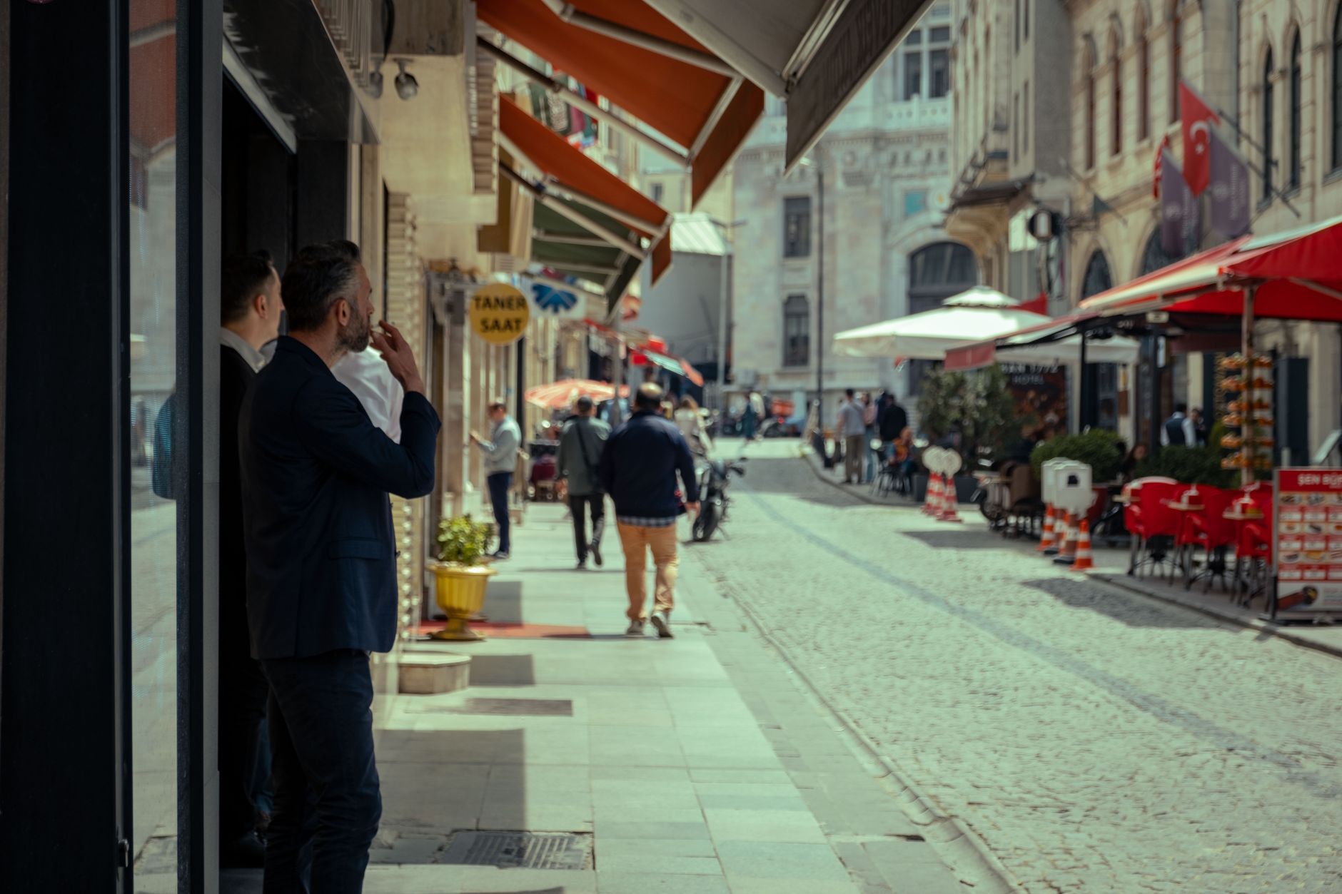 A busy street in Istanbul with cafés, shops, and people strolling.