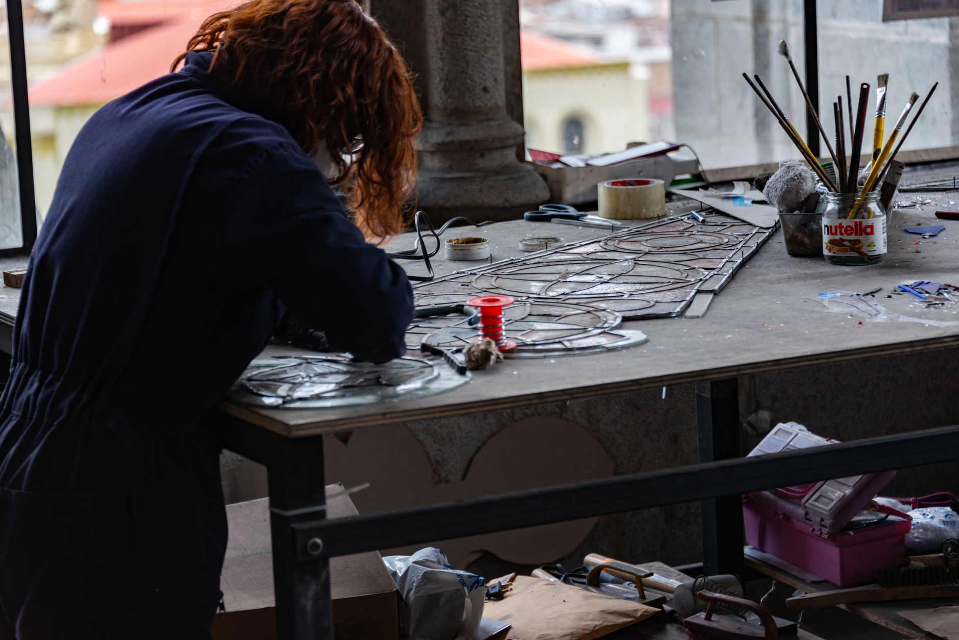 İzmir'deki bir atölyede vitray panel üzerinde çalışan bir zanaatkârın yakın planı.